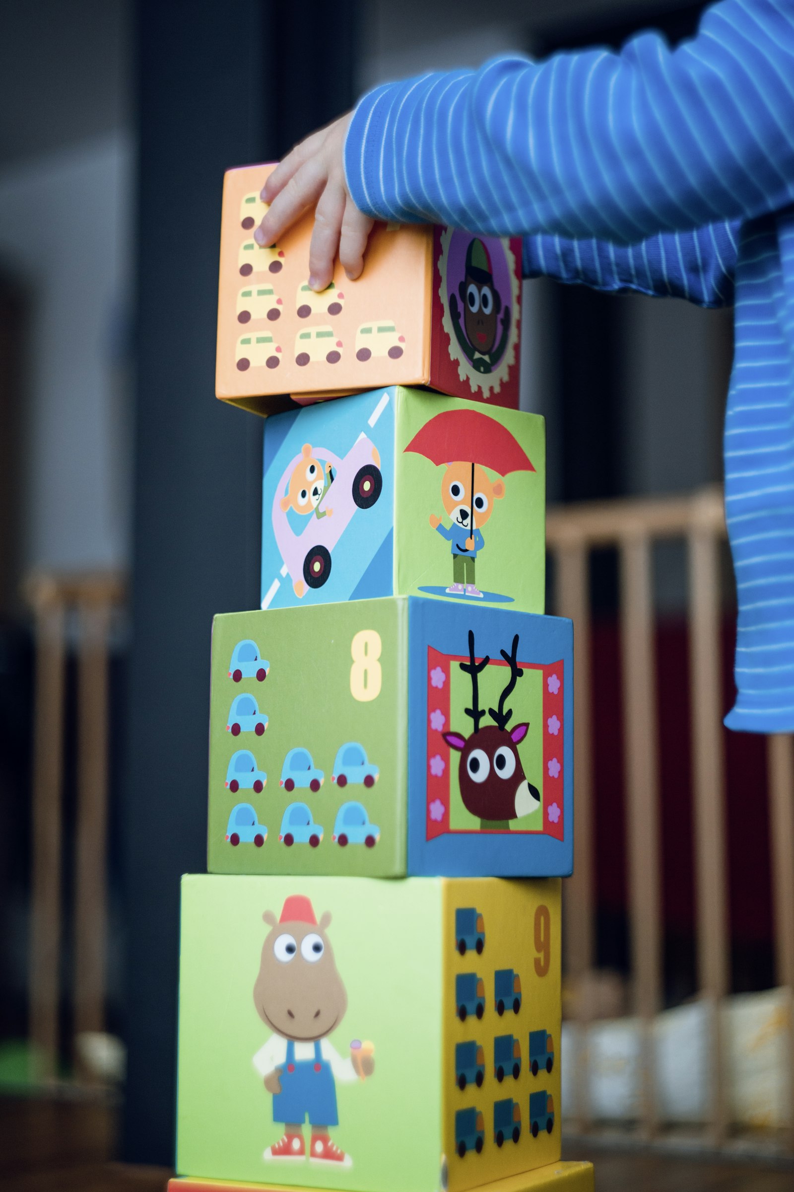 A child stacking colourful cardboard blocks