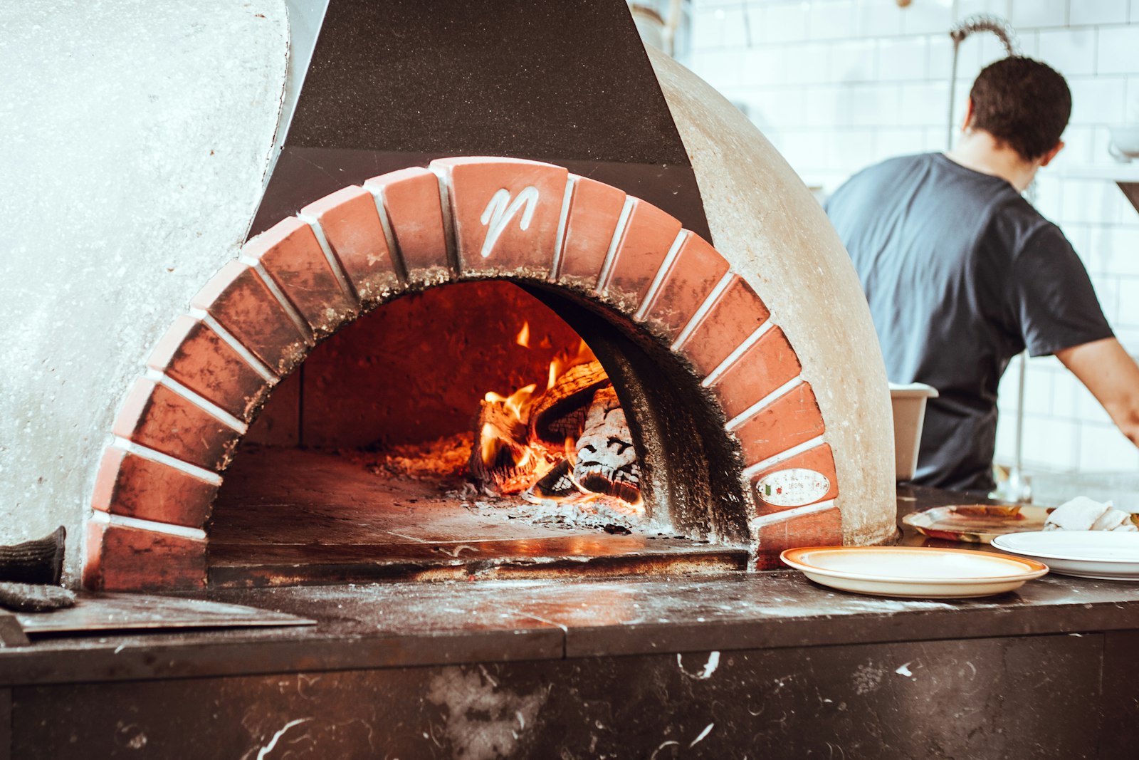 A brick-arched wood-fired oven with the fire burning