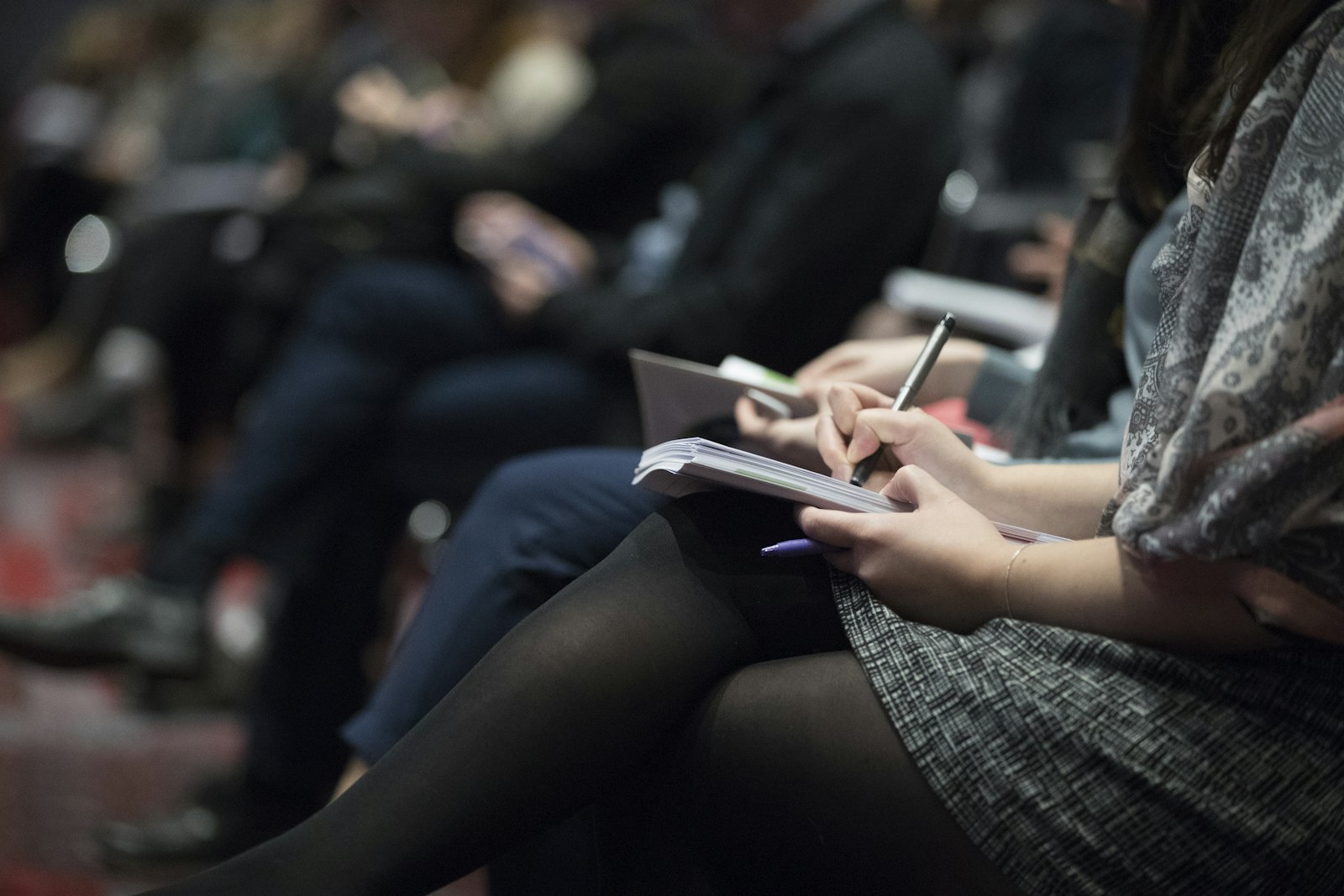 Attendees in a row taking notes