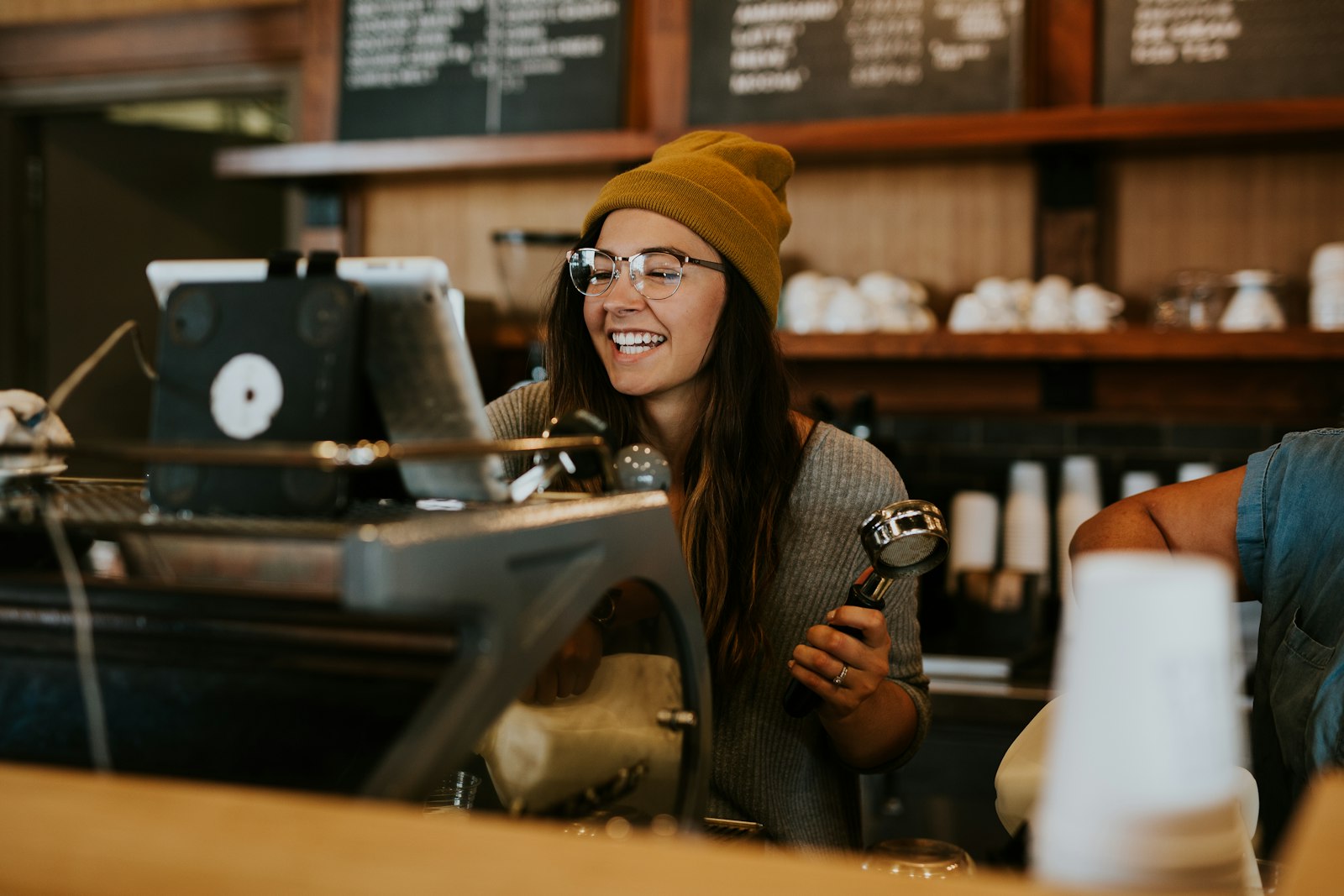 A barista behind the counter holding a portafilter