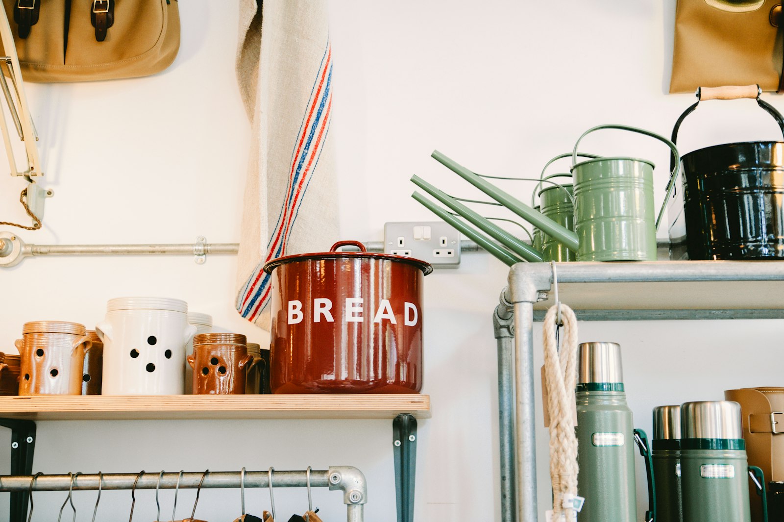 An enamel bread bin and linen towel on shelves