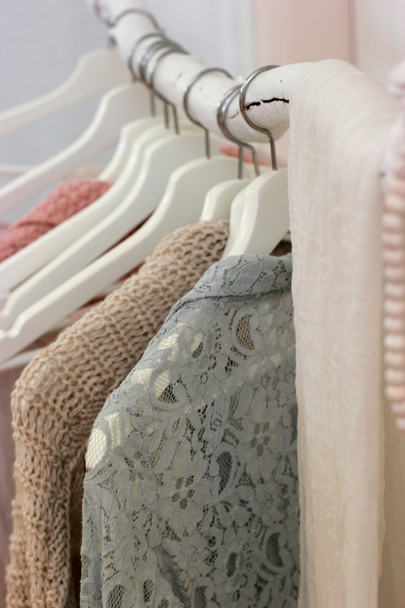 A lace blouse and knitwear on white hangers
