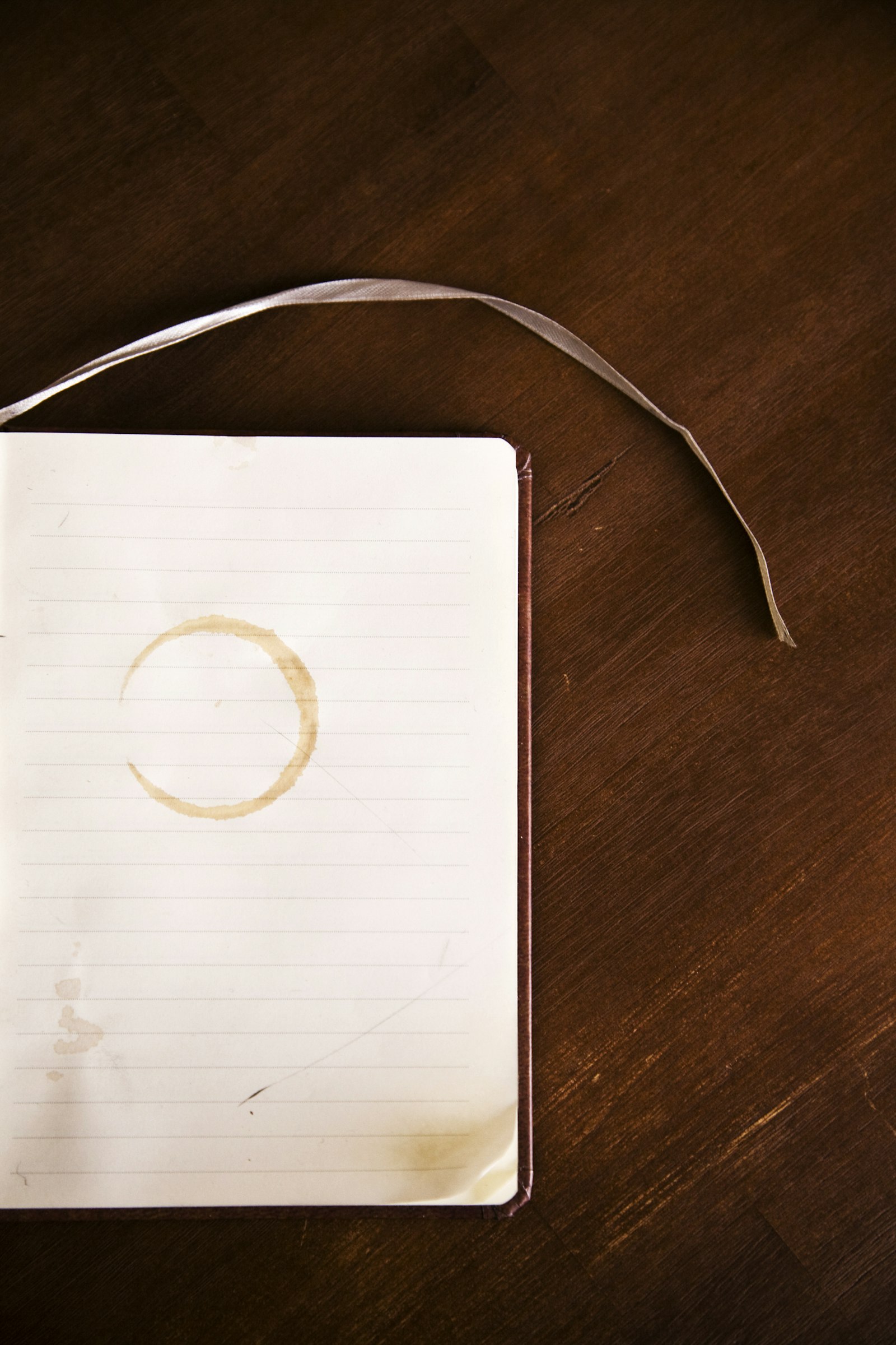 An open notebook with a coffee ring, photographed from above