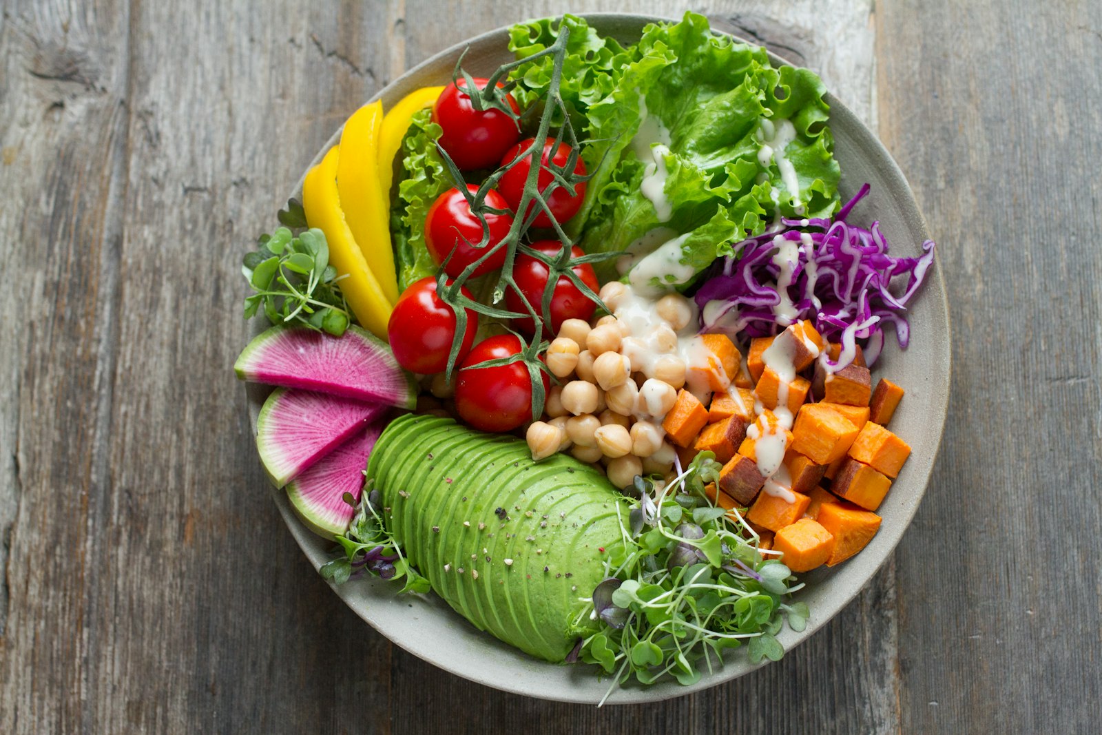 A bowl of avocado, chickpeas, sweet potato and radish