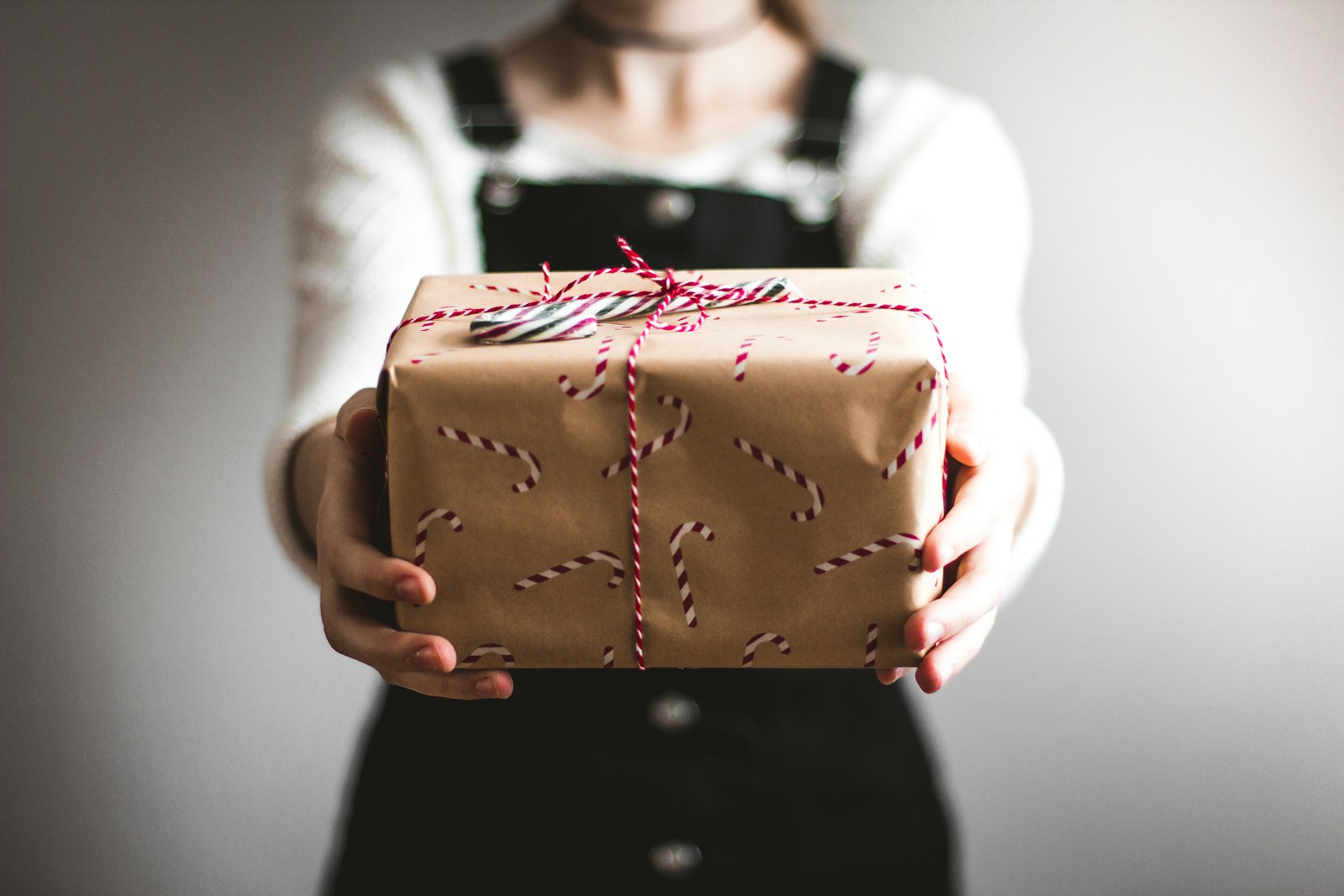Hands holding a kraft-paper parcel tied with twine