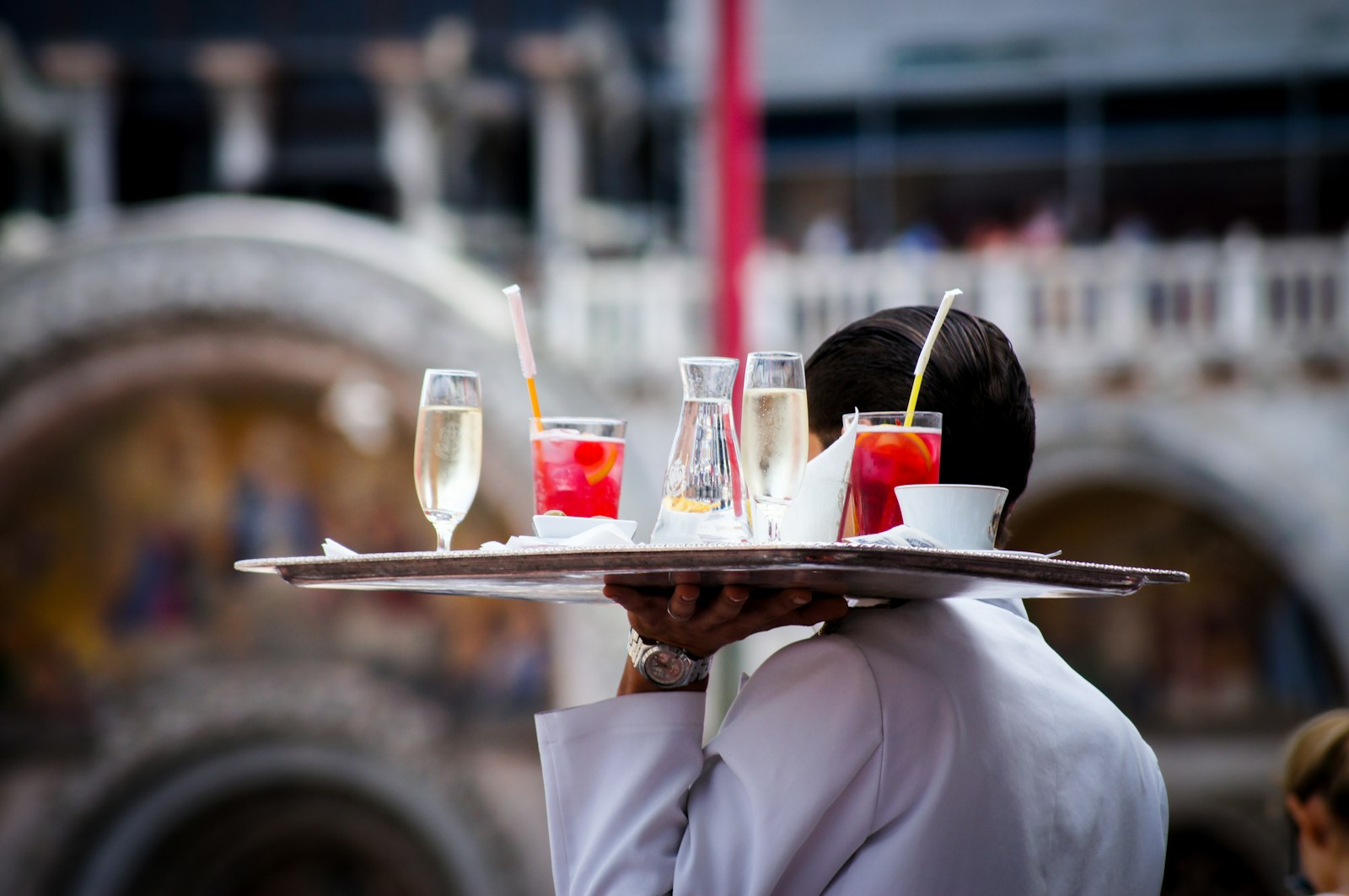 A waiter carrying drinks at an outdoor event
