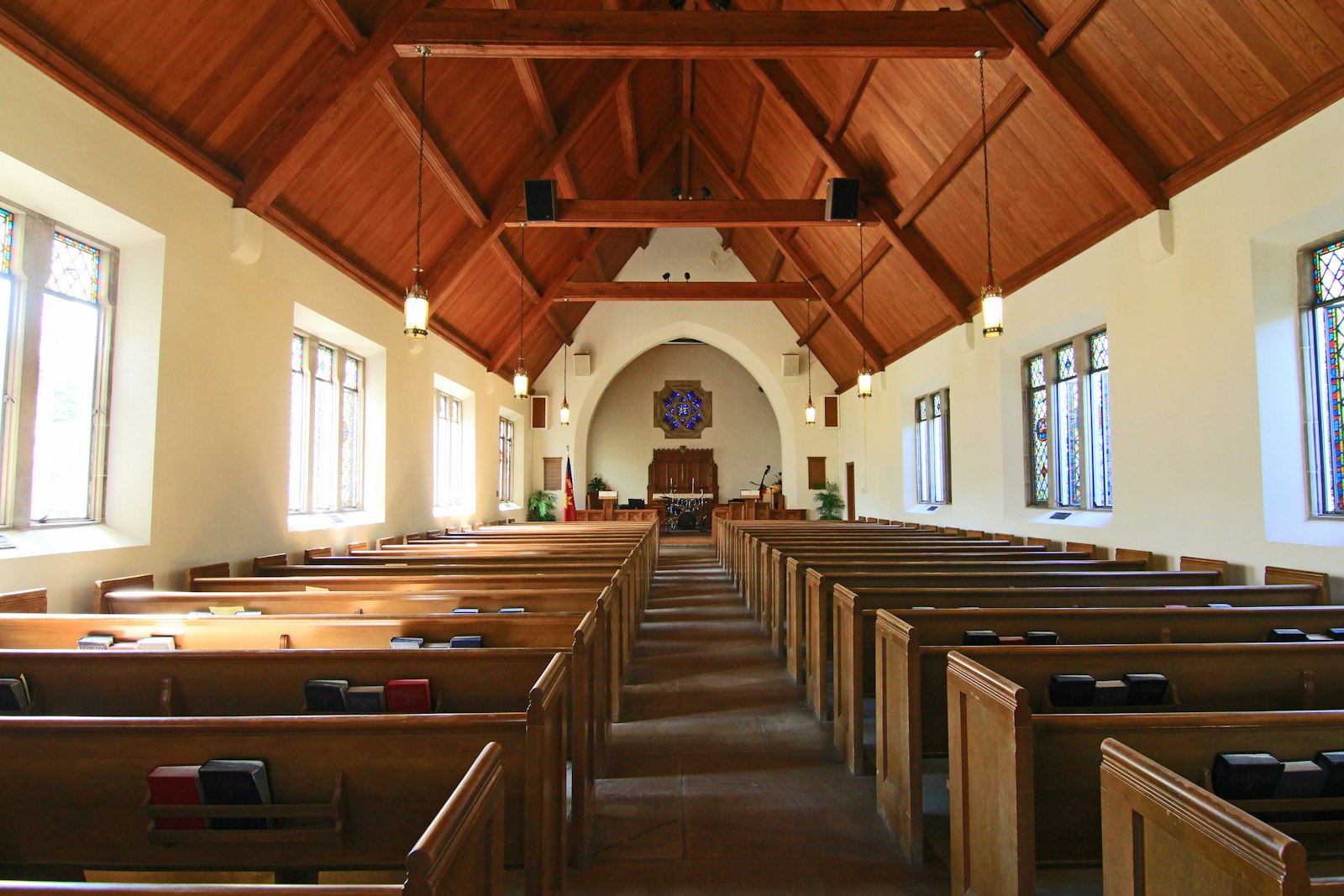 A bright church interior with a timber roof and rows of pews