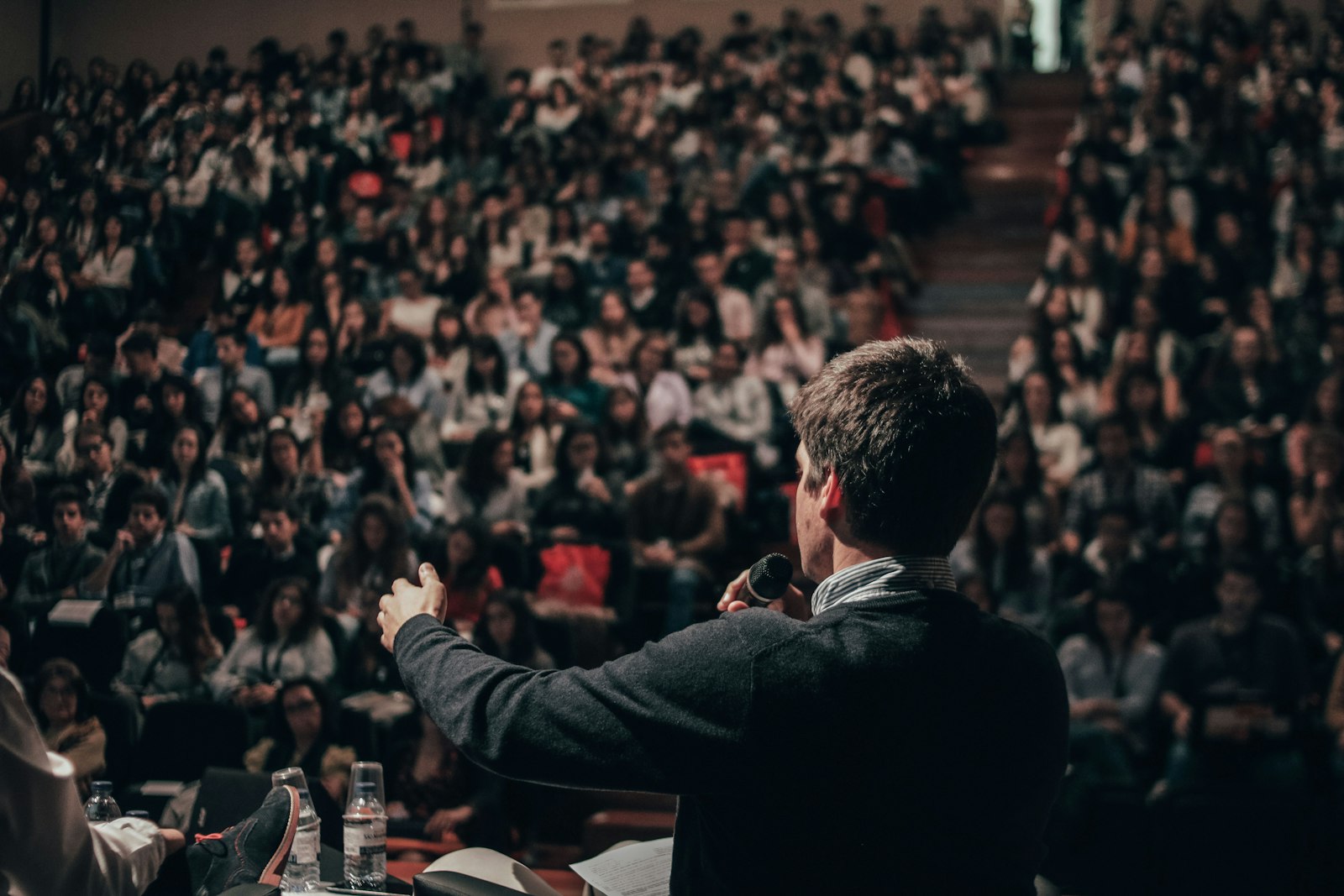A speaker facing a packed auditorium