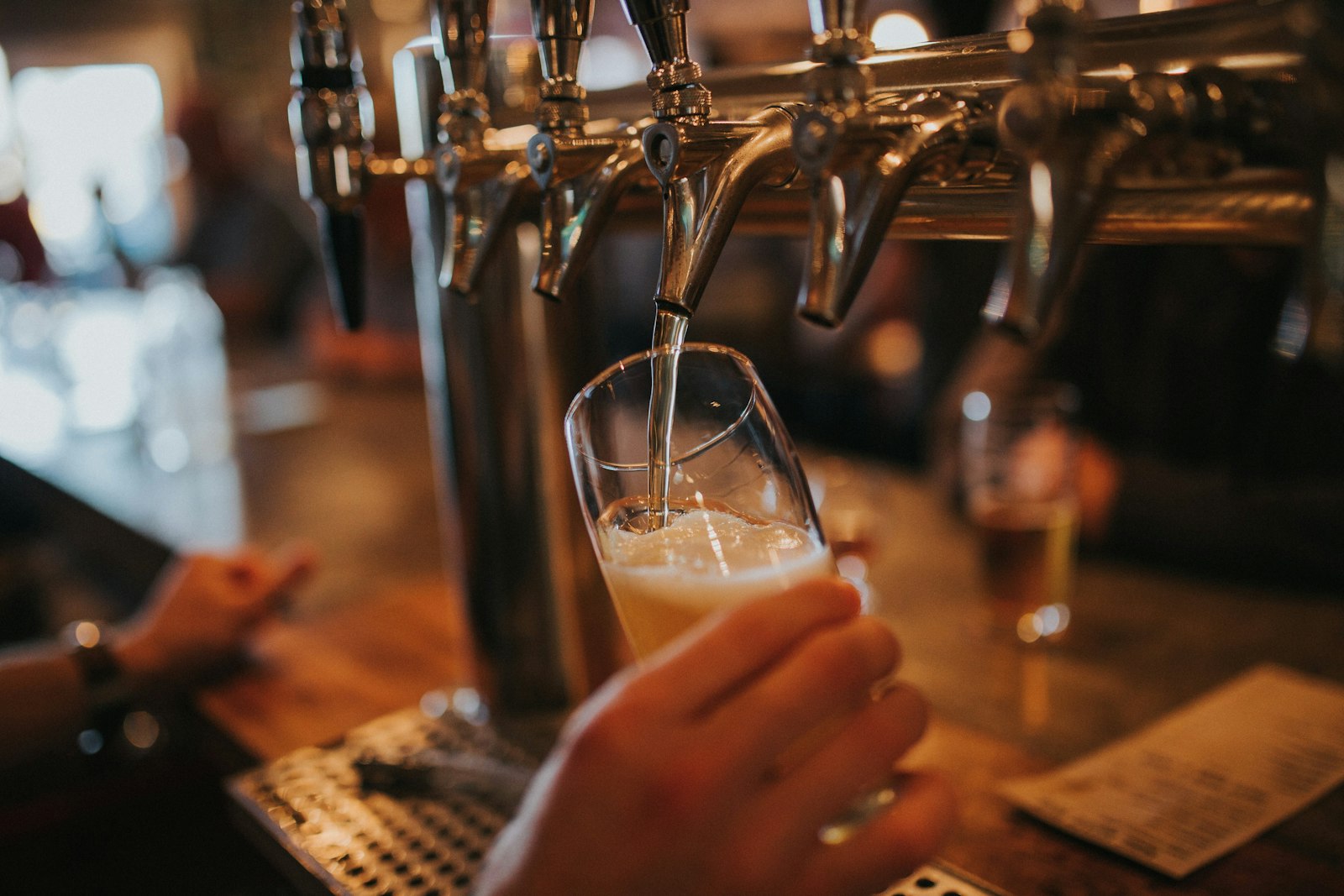 A glass filling from a row of taps