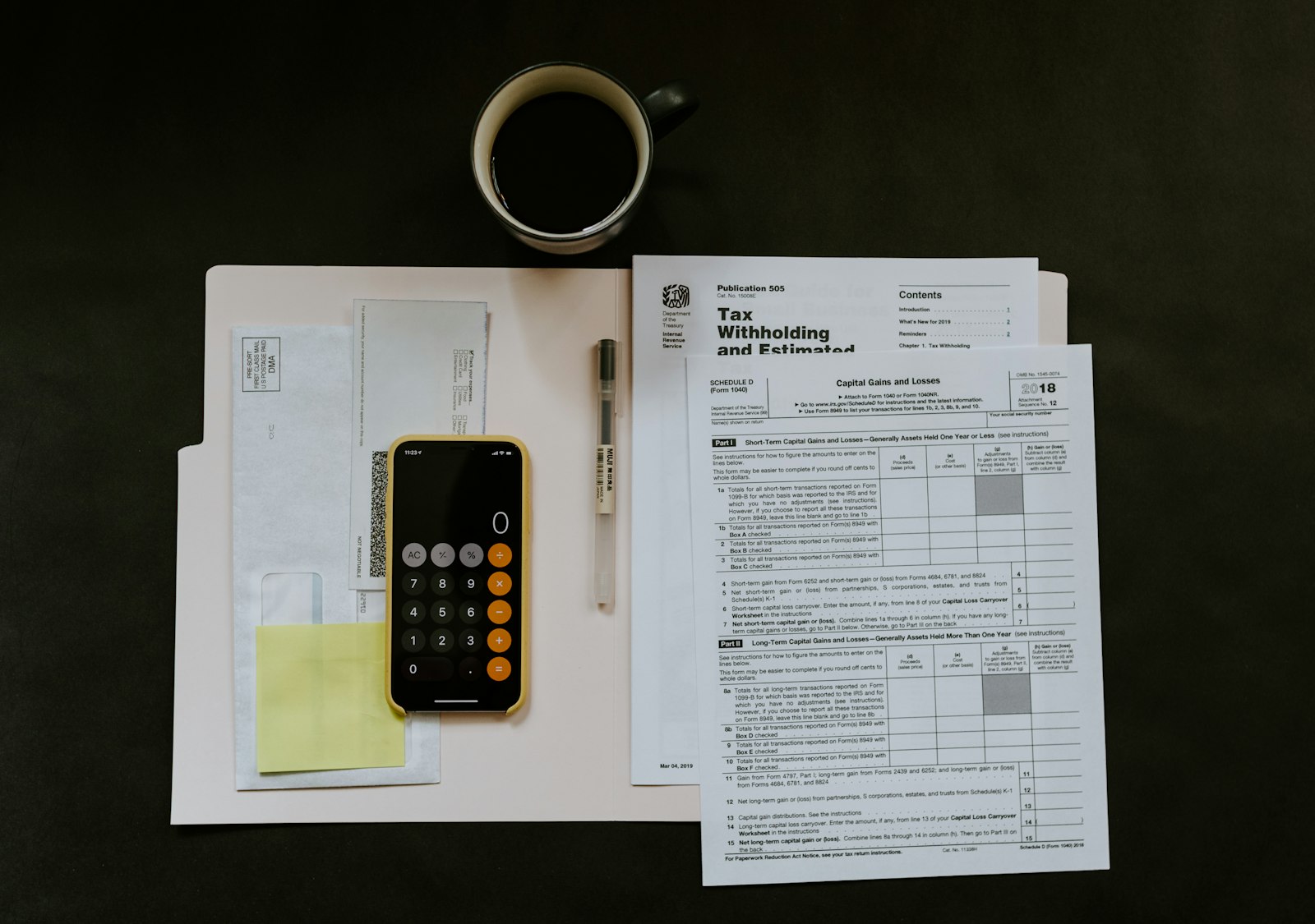 A phone, a pen and a tax form on a white folder