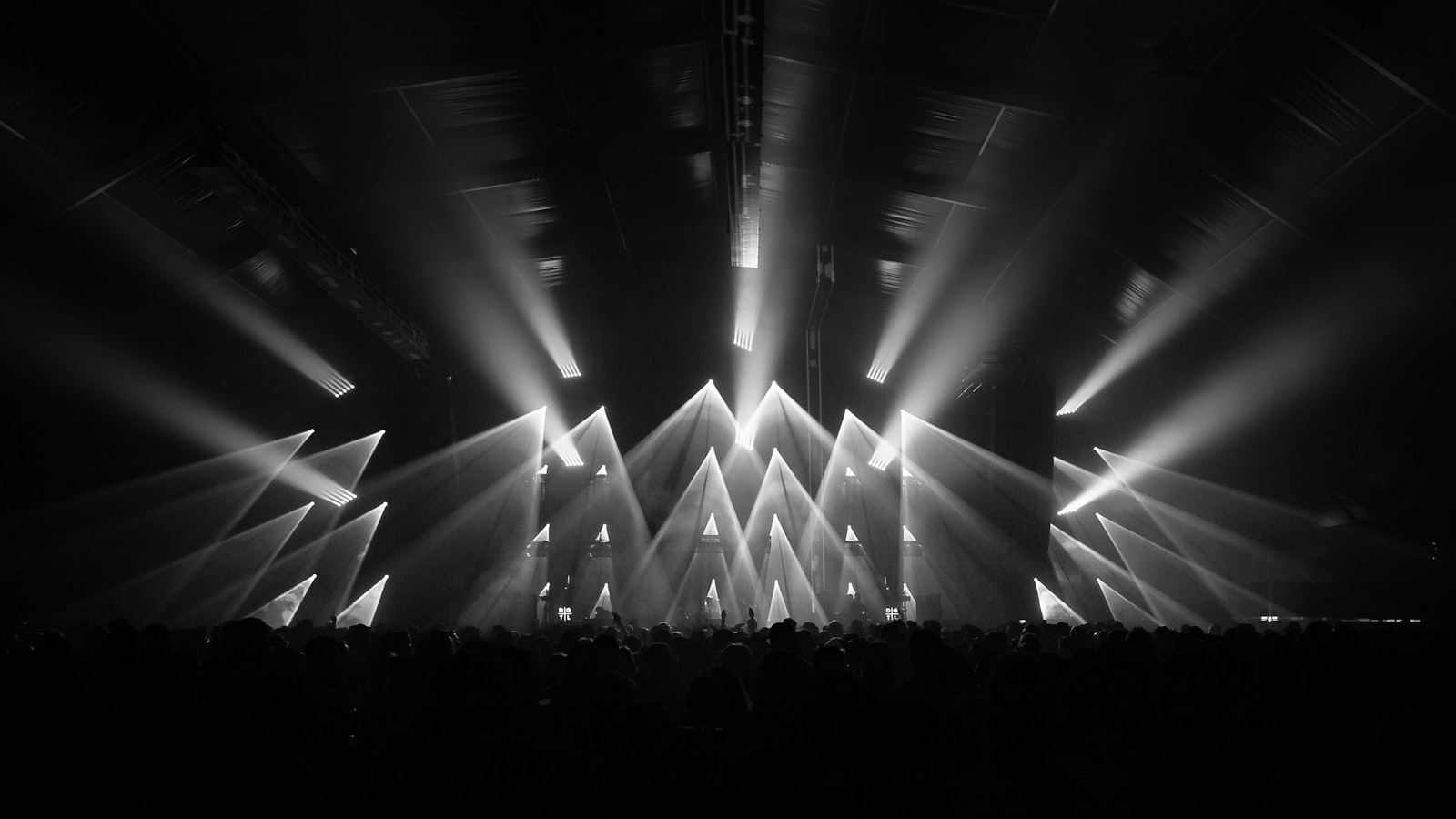 Stage lights cutting through a crowd