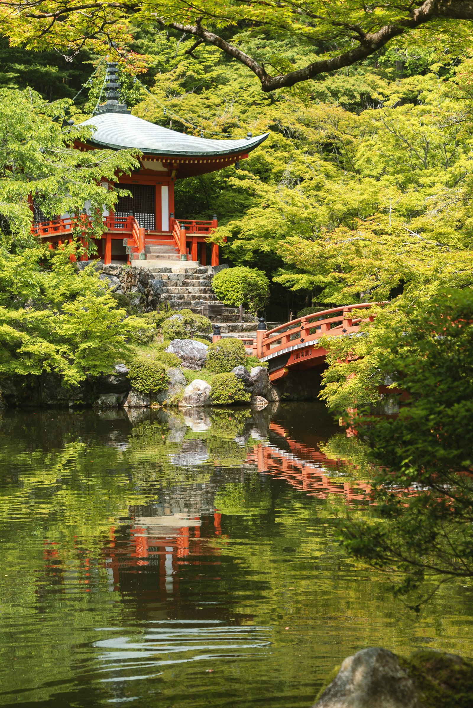 A red Japanese temple hall reflected in a pond