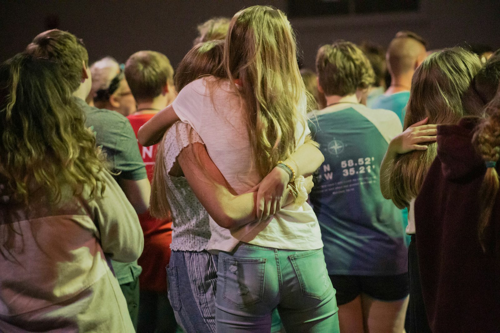 Young people with their arms round each other at a youth group