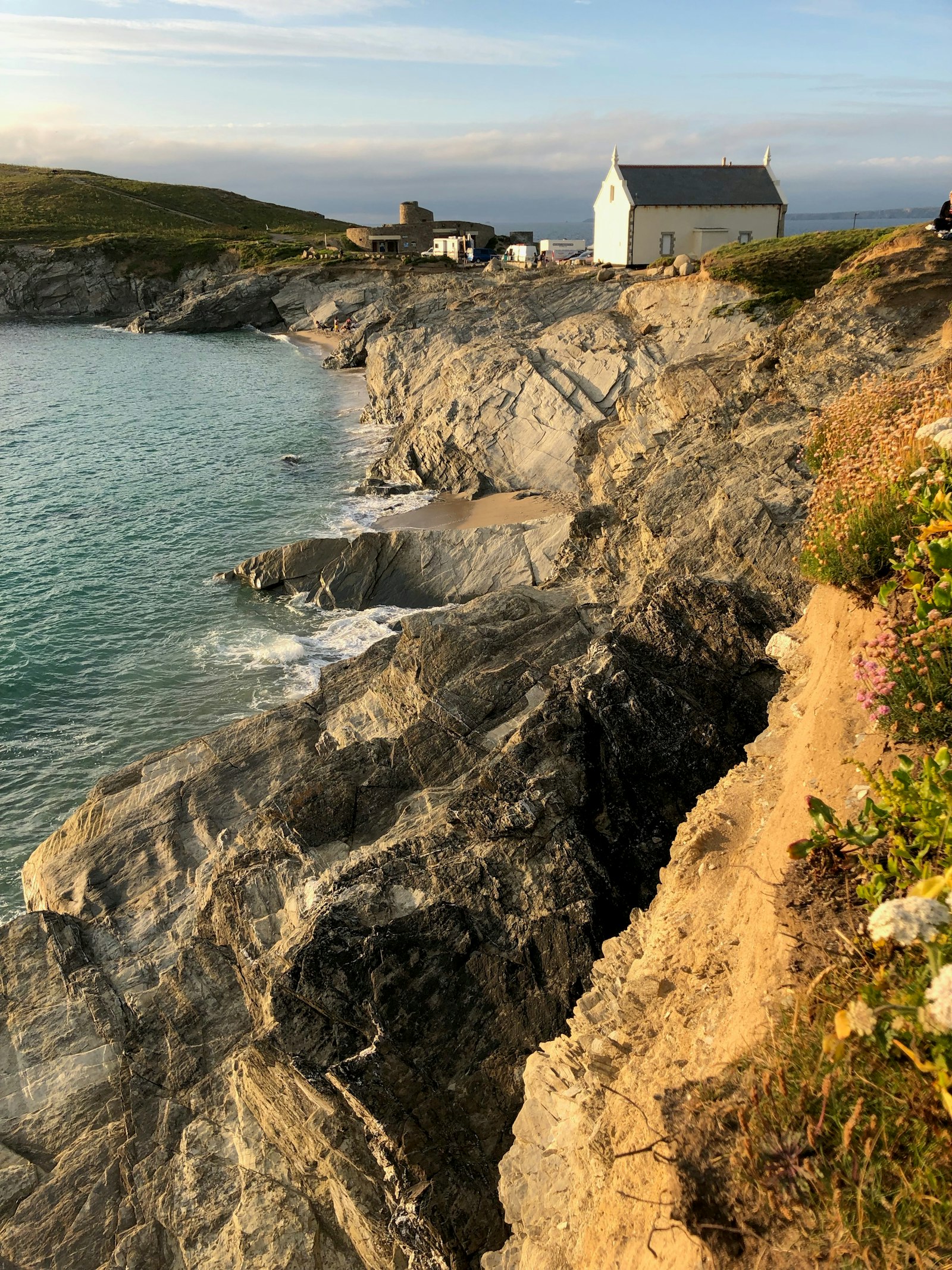 White cottages on a clifftop above a rugged coast