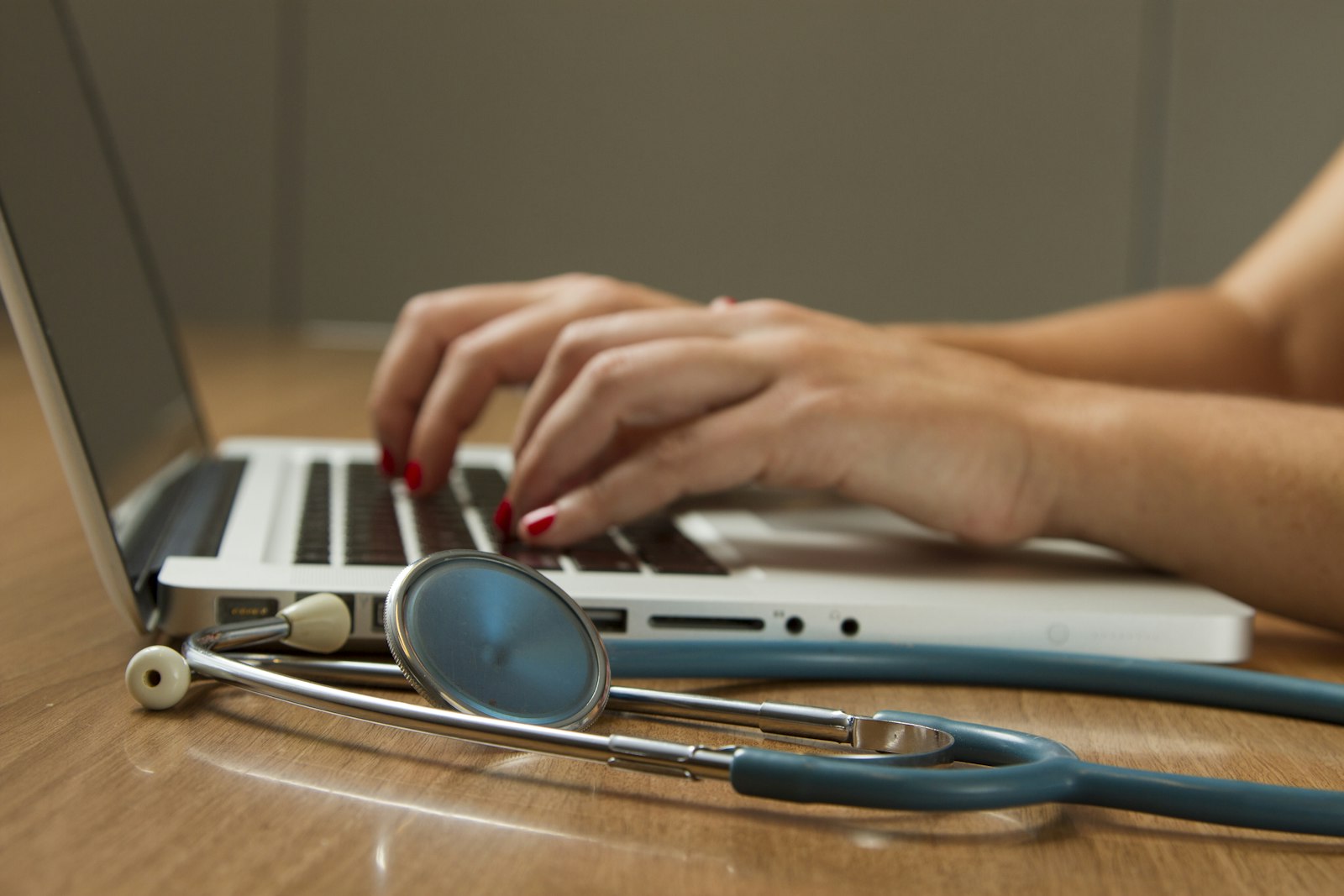 A desk with a laptop and a stethoscope
