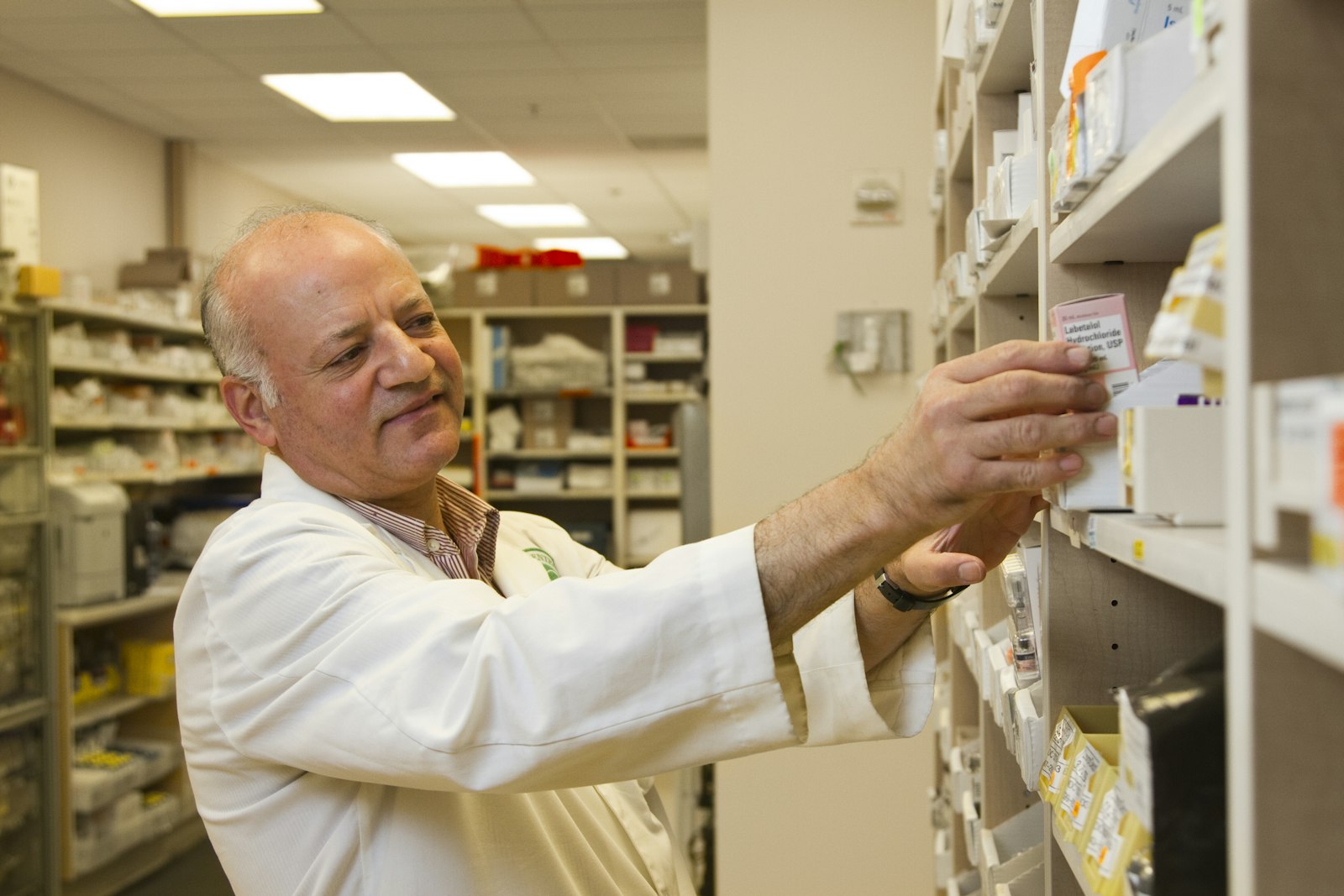 A pharmacist holding a prescription at the counter