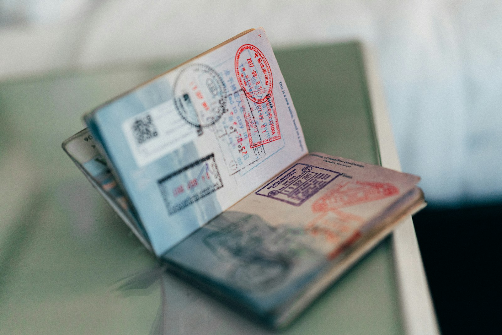 Open passport pages covered in colourful entry stamps