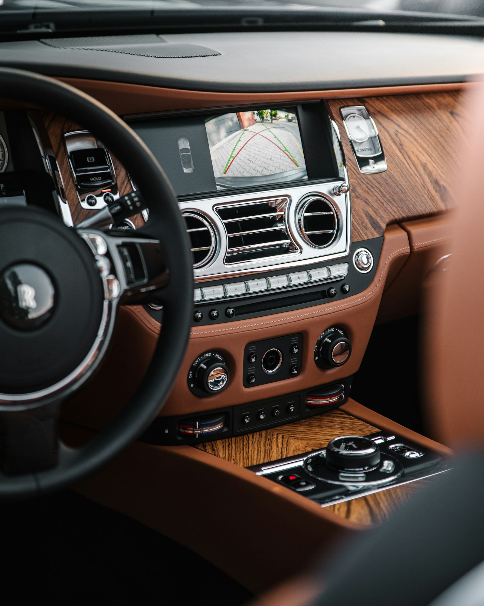 A dashboard finished in tan leather and wood veneer