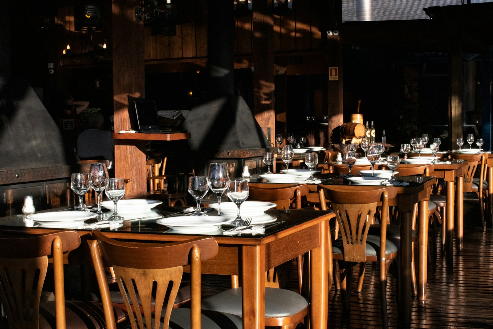 A dark wood dining room with set tables
