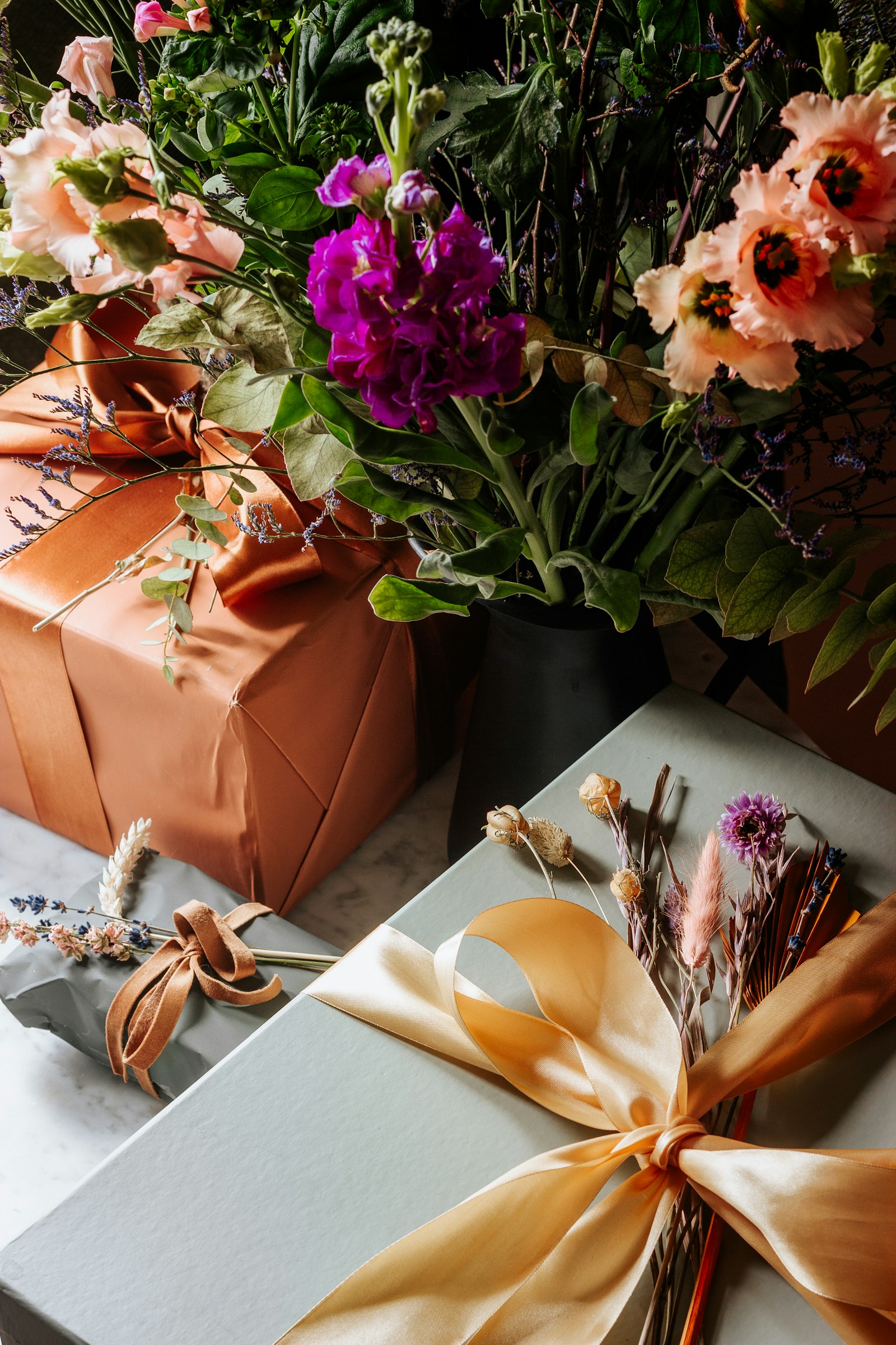 Copper and sage wrapped gifts with ribbon and dried flowers