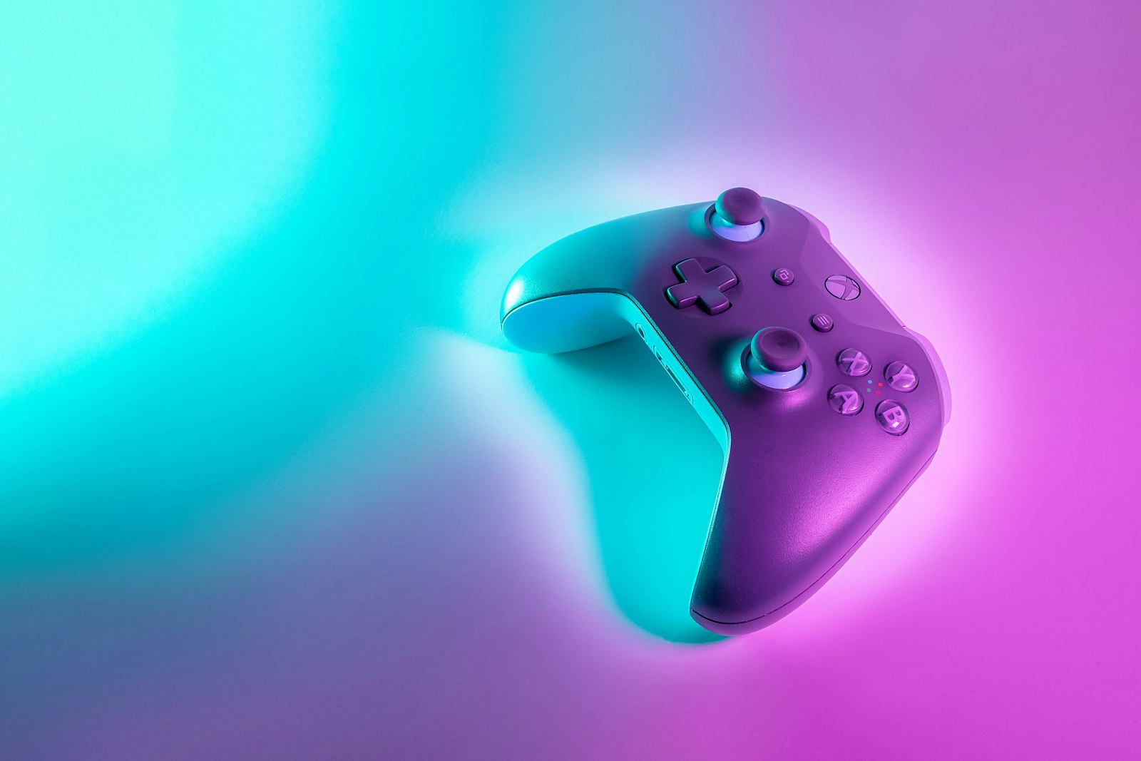 A game controller in cyan and magenta neon light