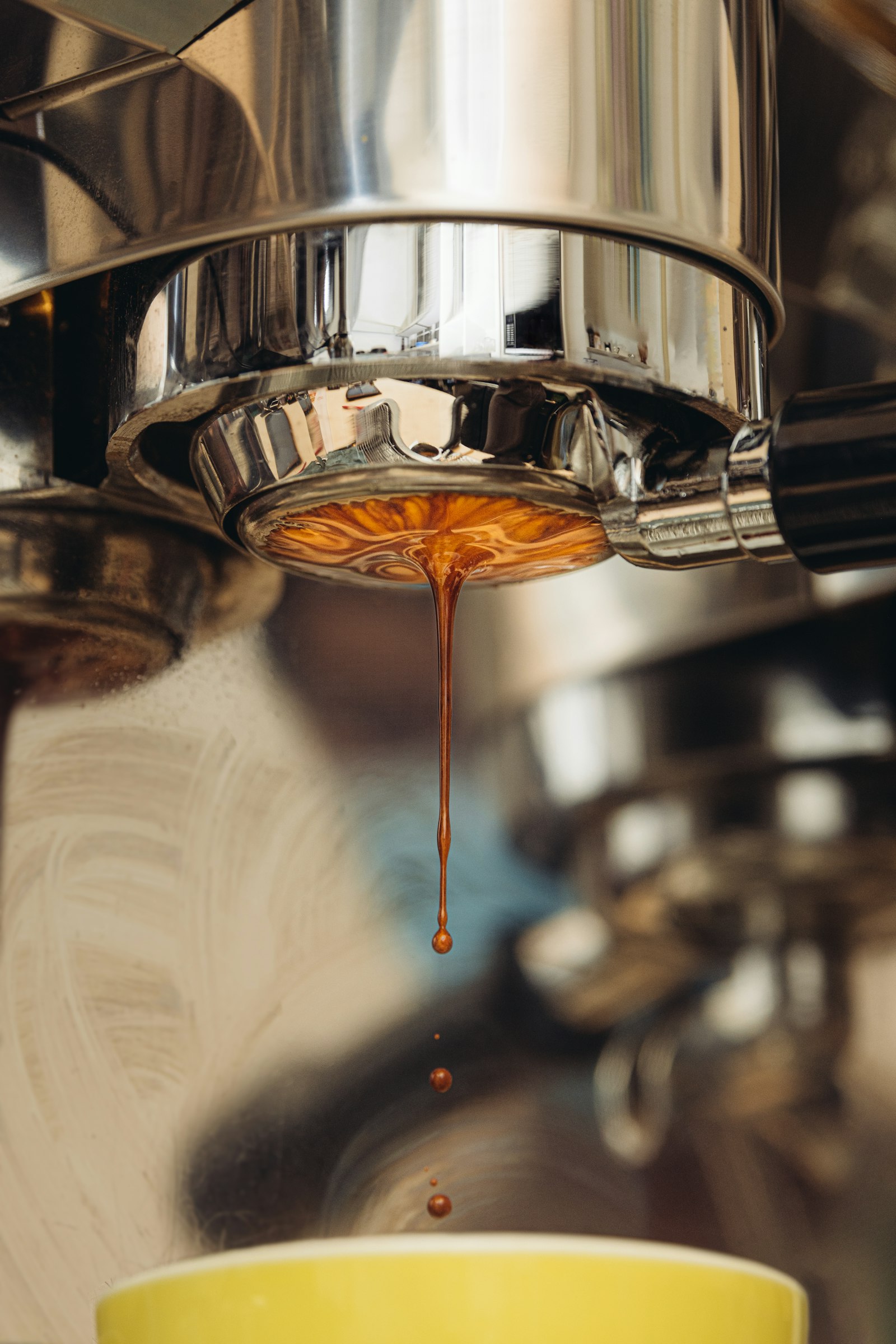 Espresso dripping from a portafilter into a cup