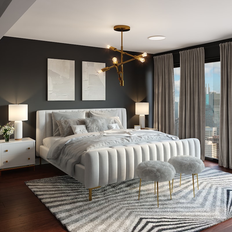 A dark bedroom with a white upholstered bed and a brass light
