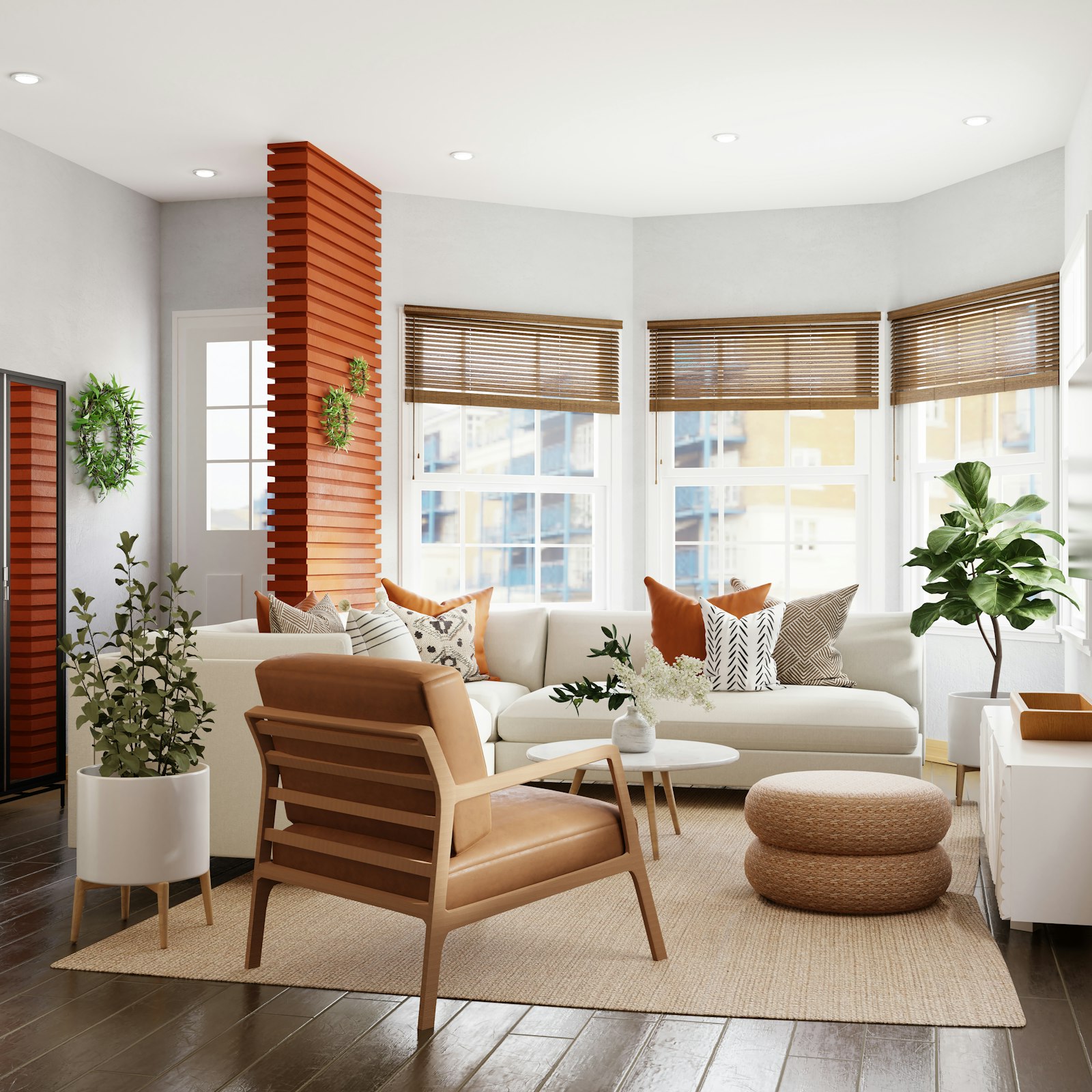 A white sectional in a bay window with terracotta accents