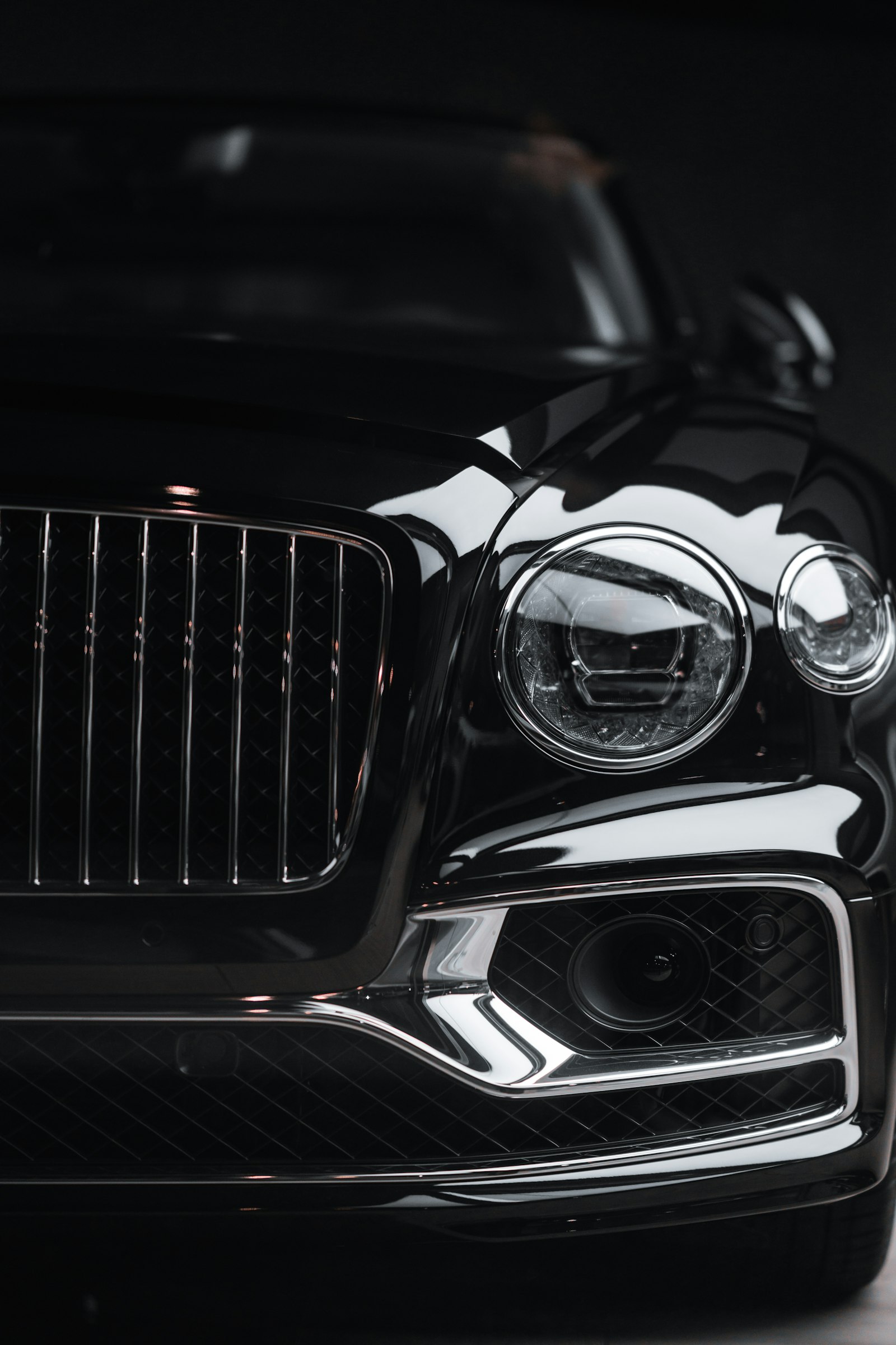 The headlight and chrome grille of a luxury car