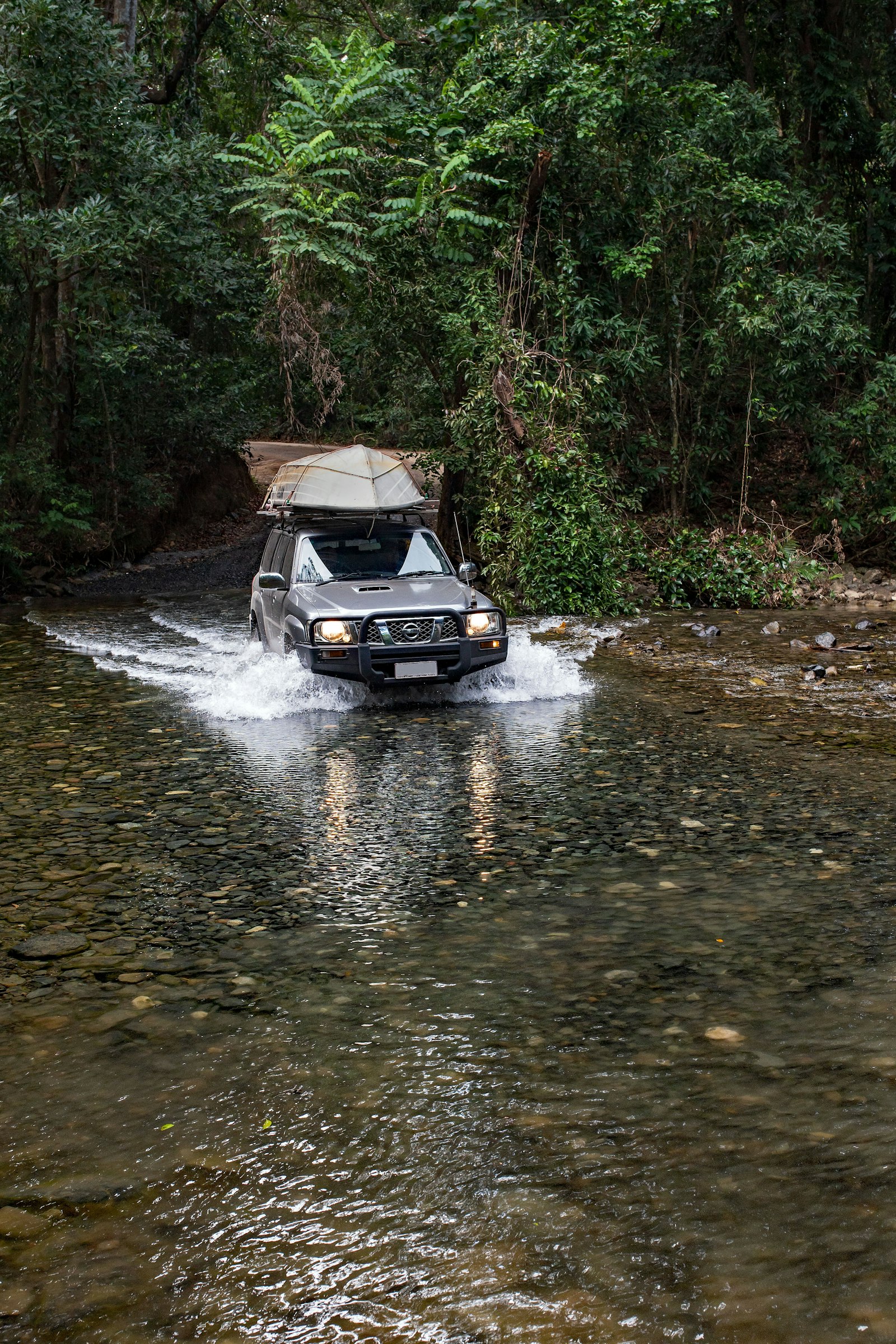 A 4x4 splashing through a forest ford