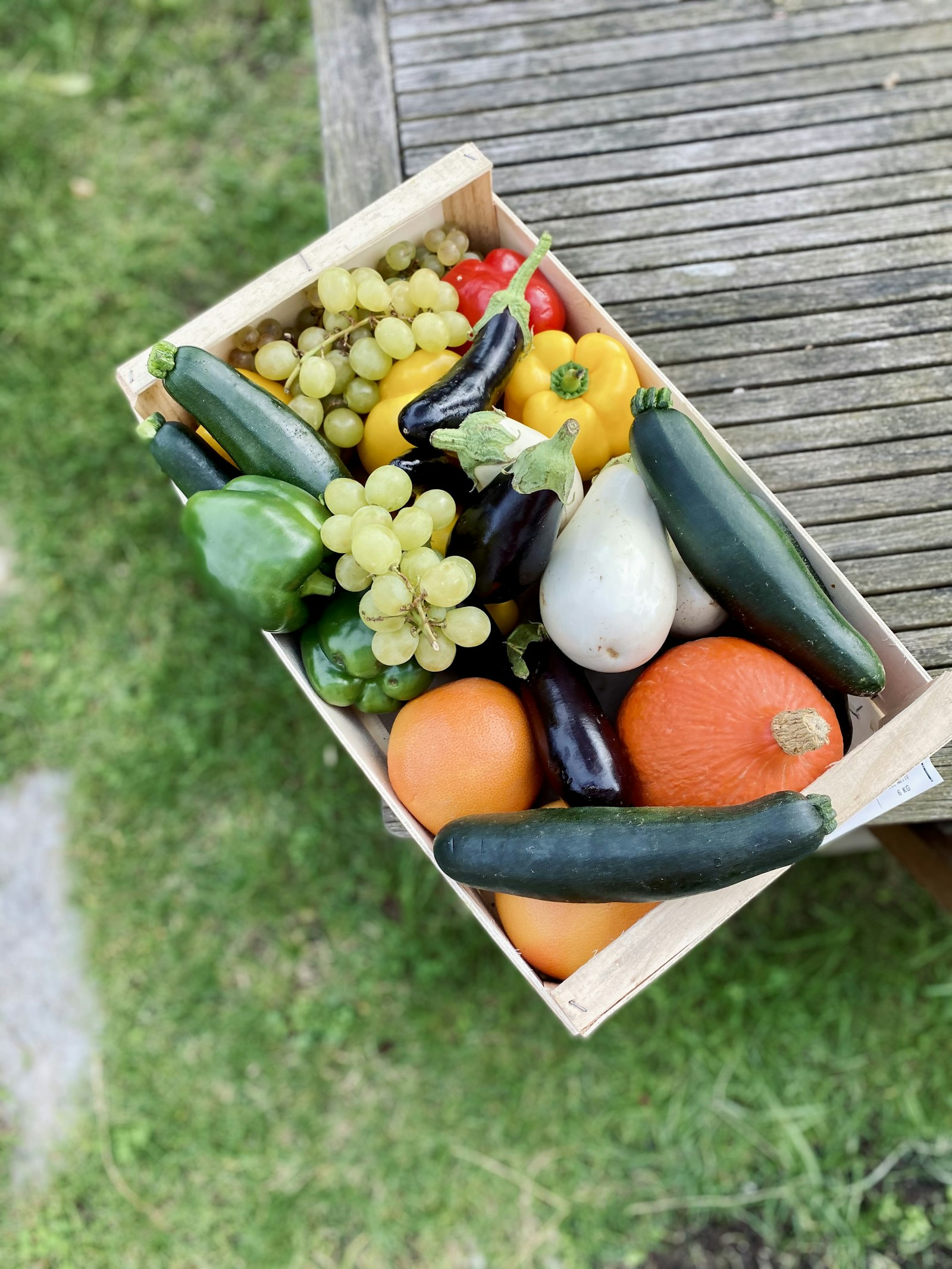 A wooden veg box held over grass