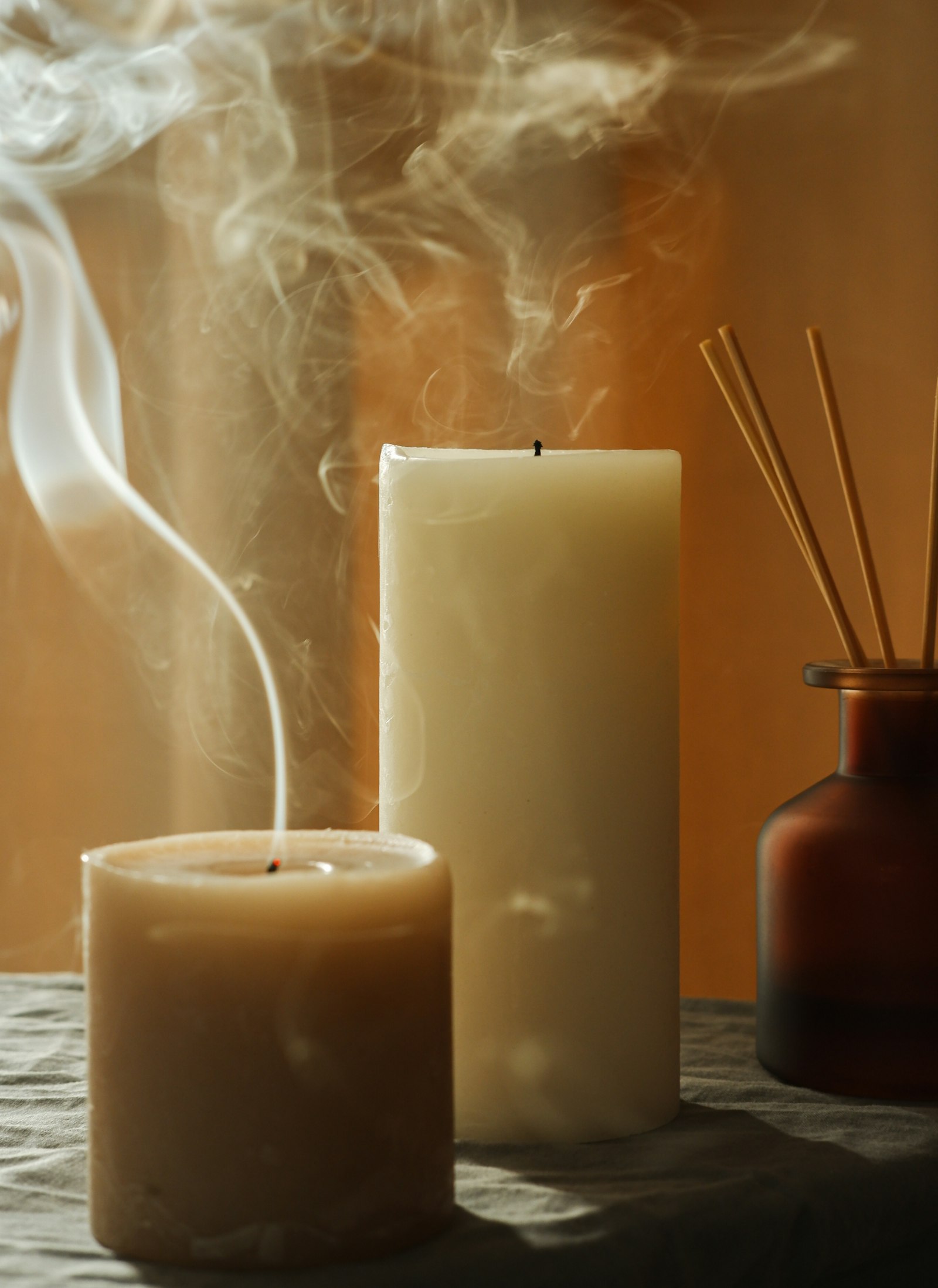 Hand-poured candles with dried-flower tops on a dark table