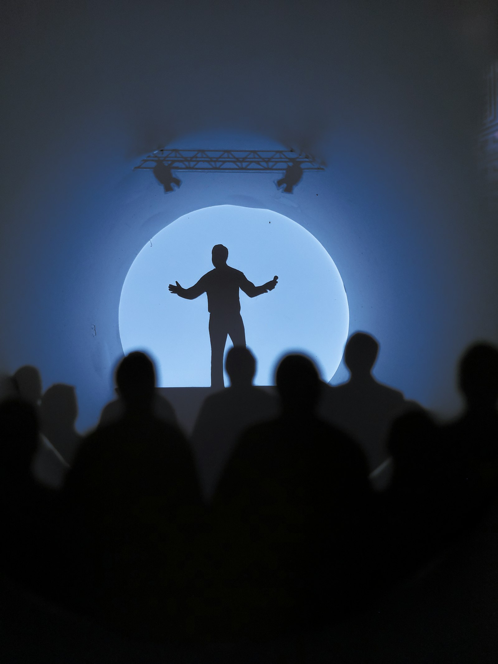 A performer silhouetted in a spotlight