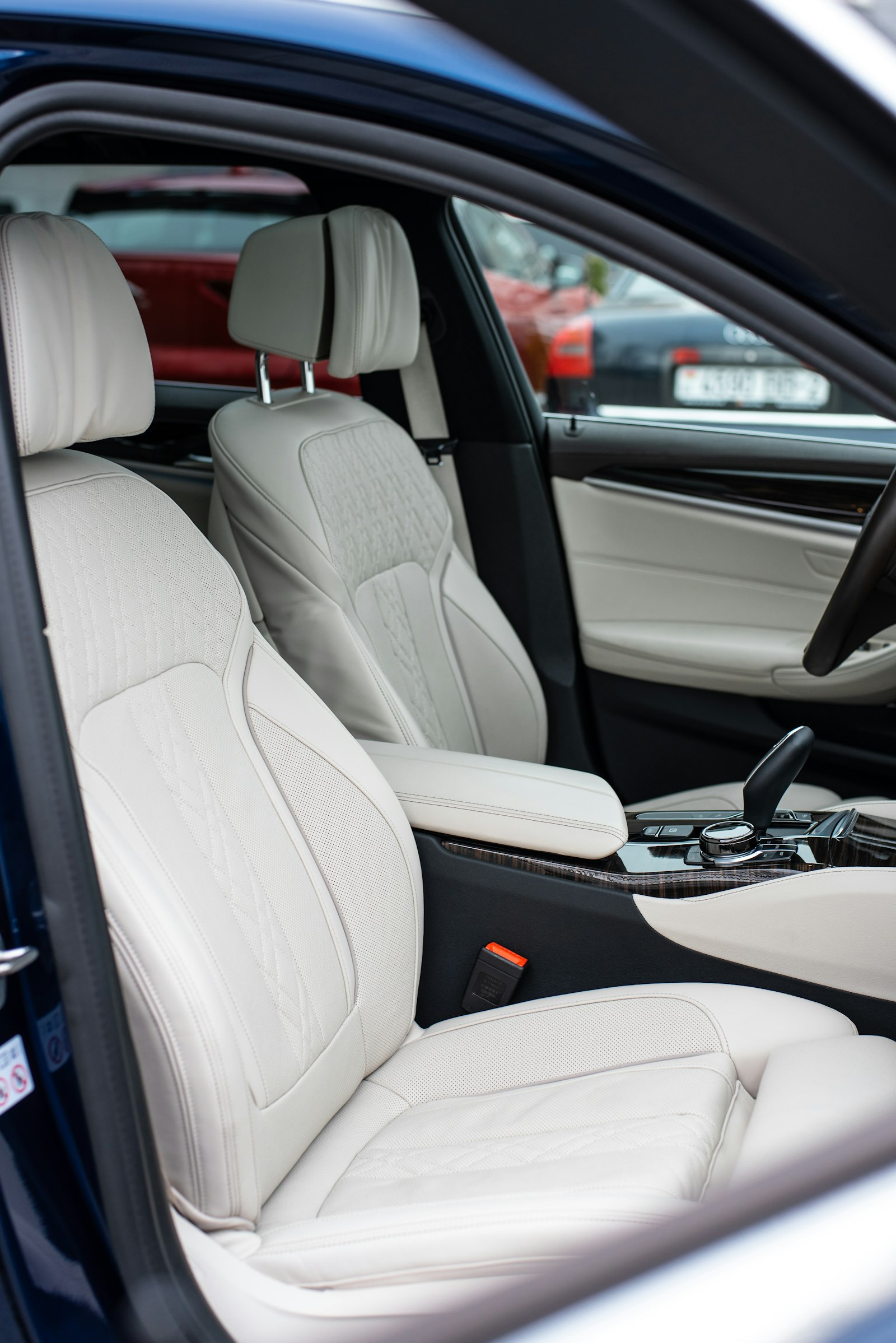 Cream leather front seats seen through an open car door
