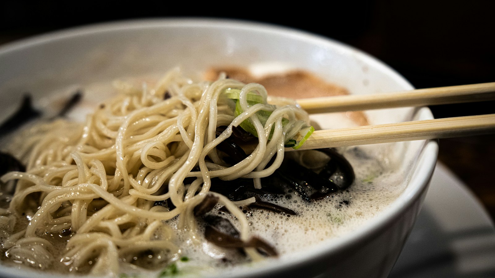 Noodles lifted from a creamy broth