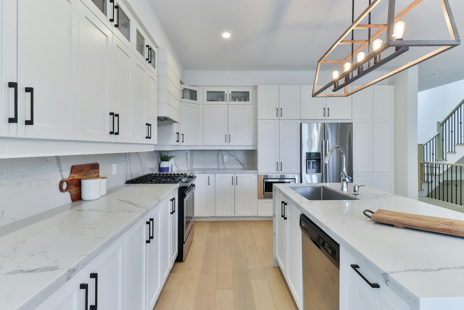 A finished kitchen with white cabinets and a wooden floor