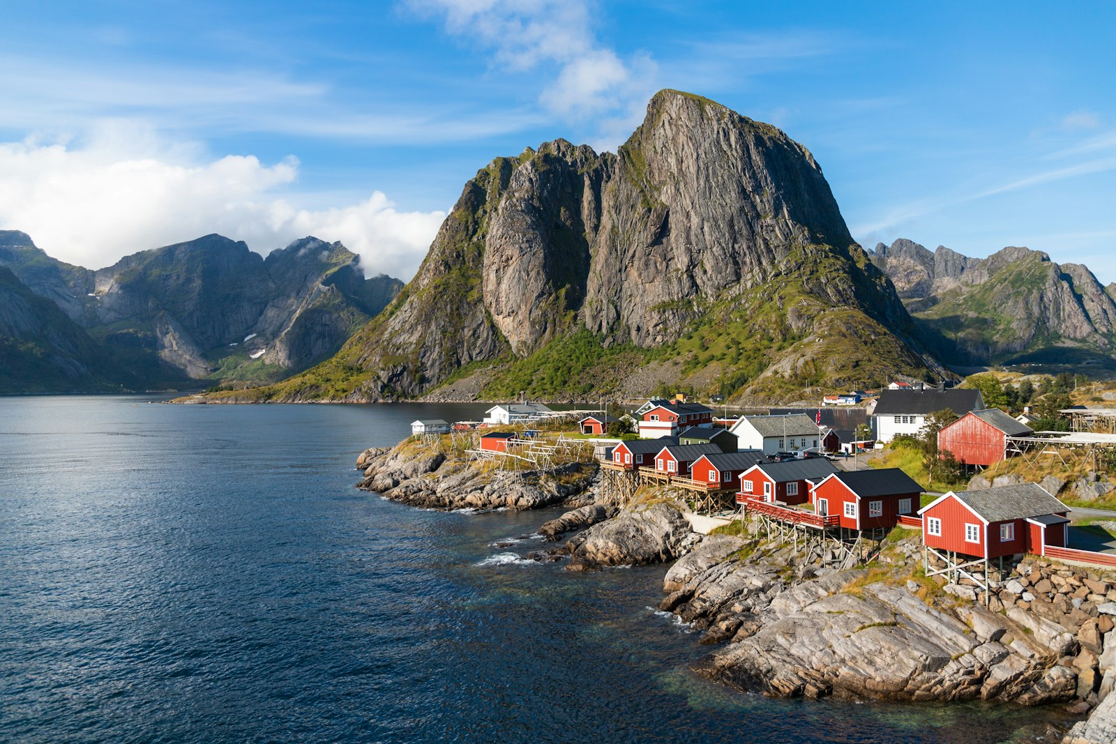 Scenic coastal harbour with fishing village and dramatic mountain backdrop