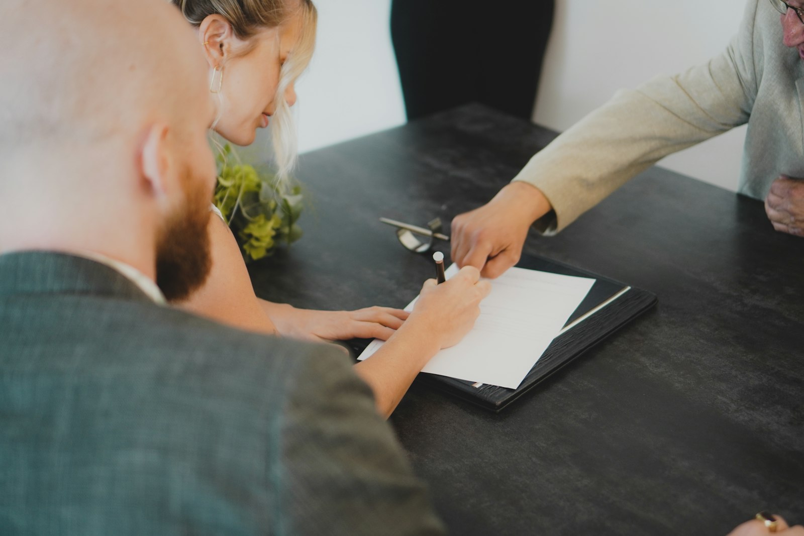 A couple signing a document at a desk