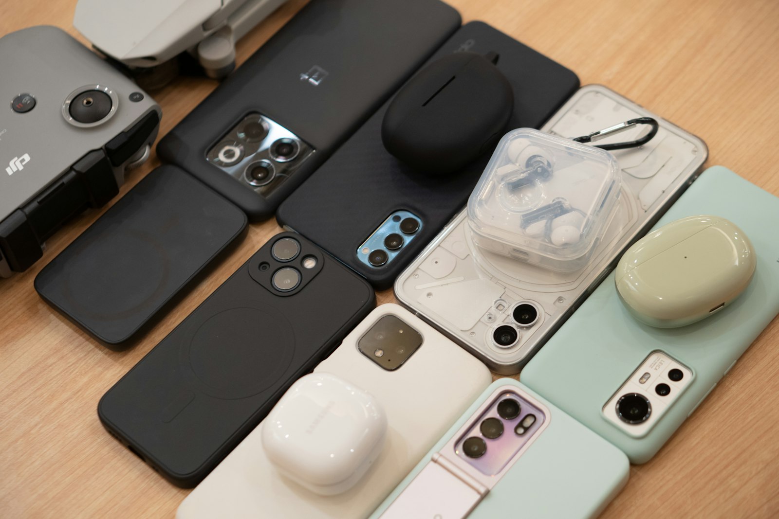 Many phones in cases packed together on a wooden table
