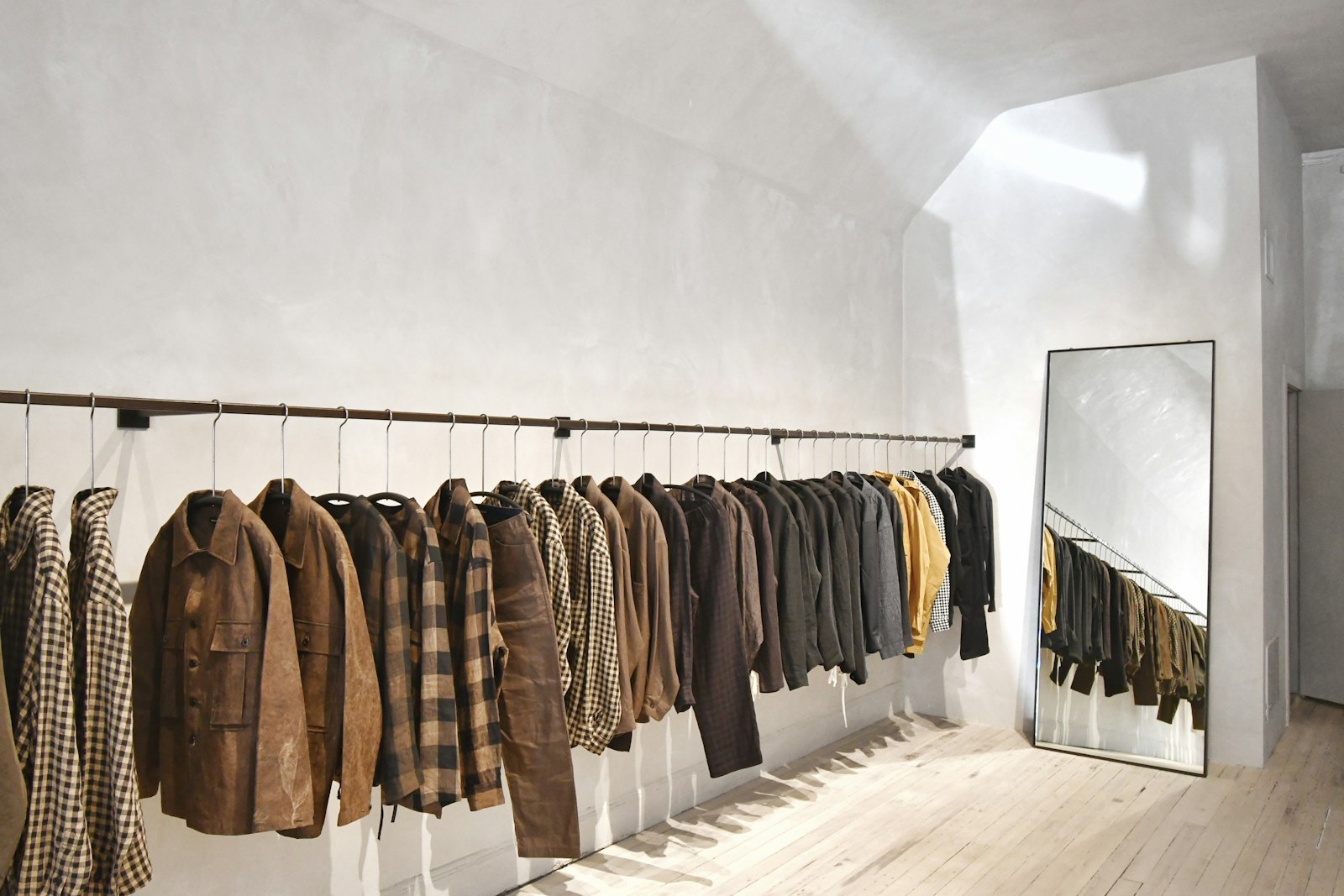 A rail of wool jackets and a floor mirror