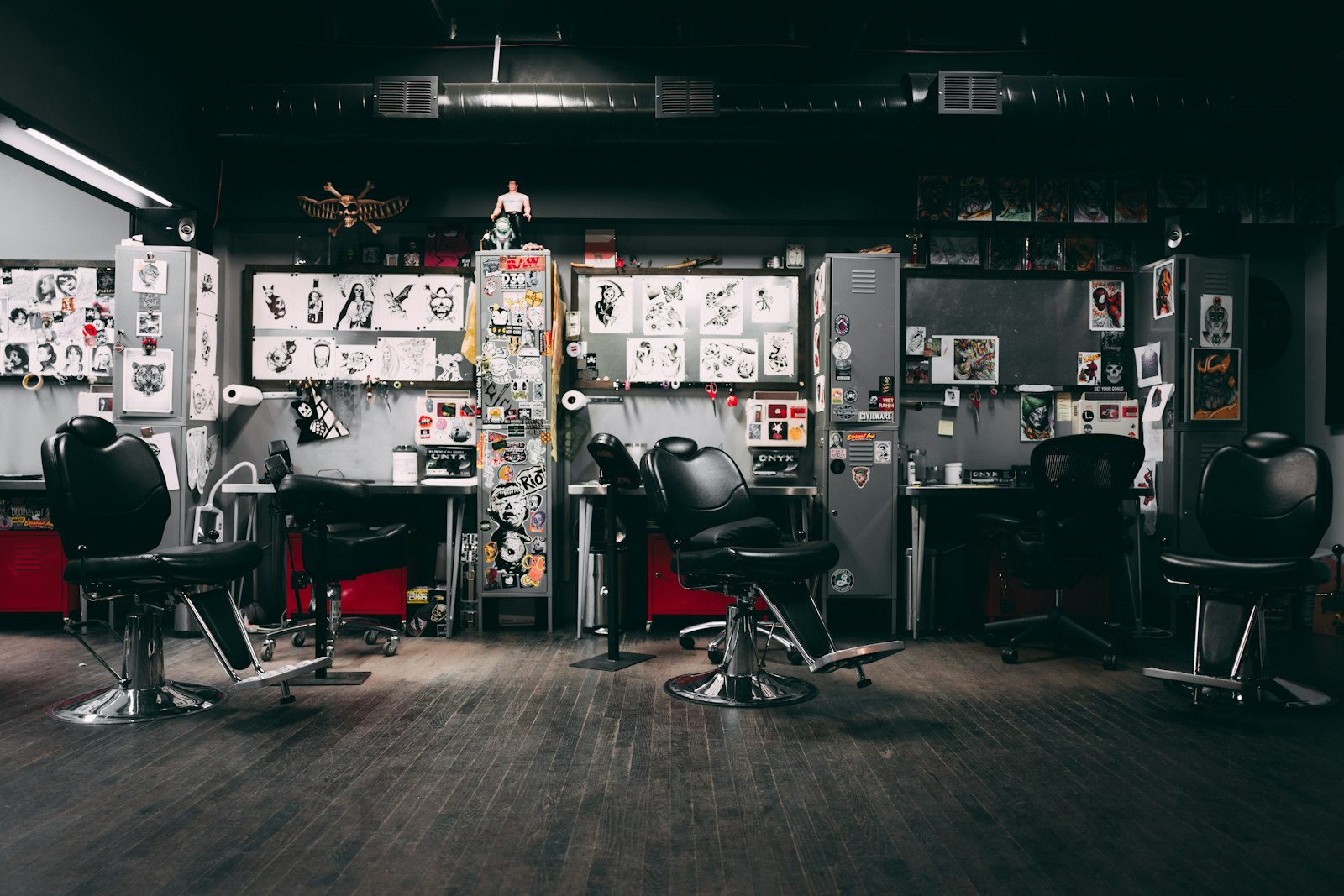 The front room: black hydraulic chairs, a wooden floor and walls covered in flash