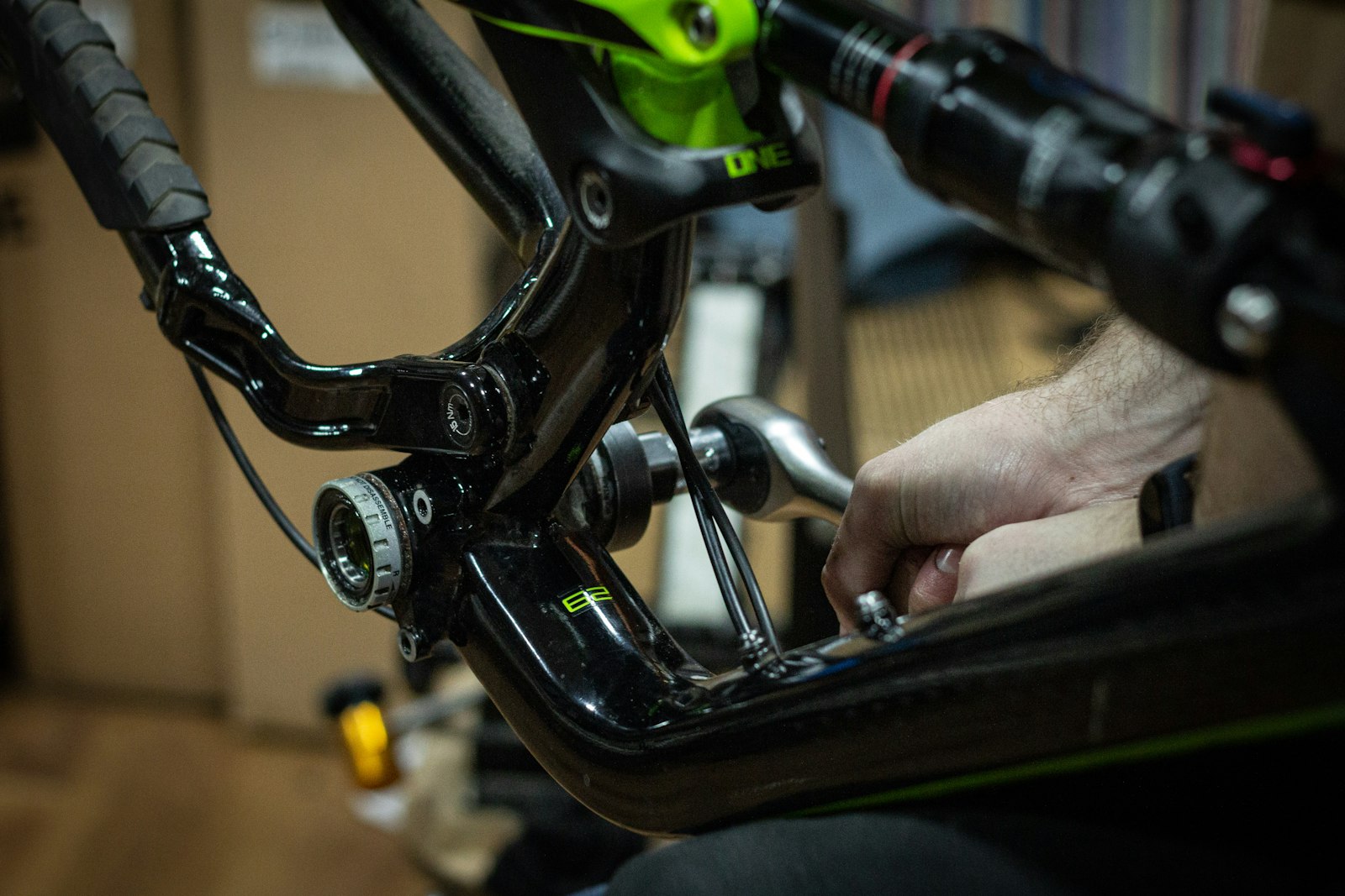 A mechanic's hands working on a mountain bike frame