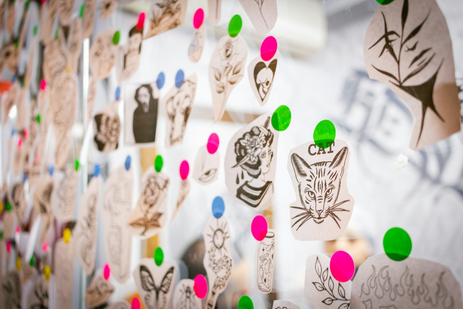 A wall of hand-drawn flash designs on paper
