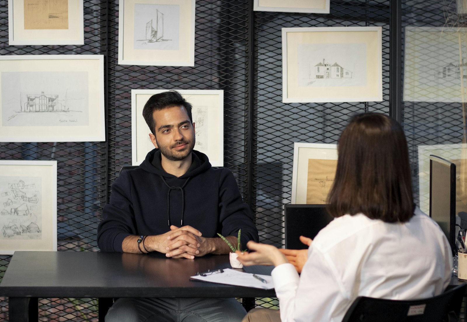 A man and a woman talking across a desk in an interview