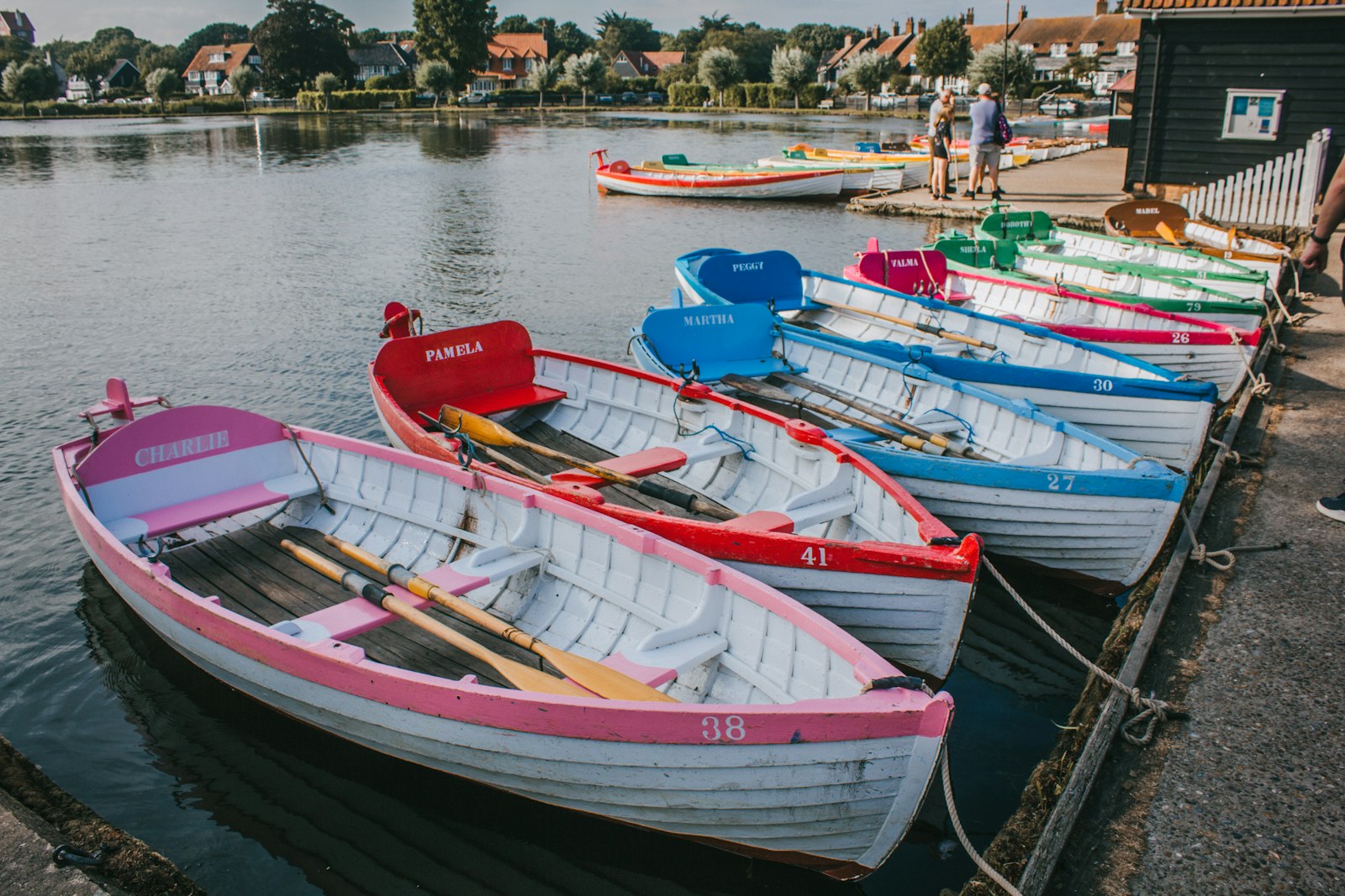 Colourful wooden rowing boats moored at a jetty