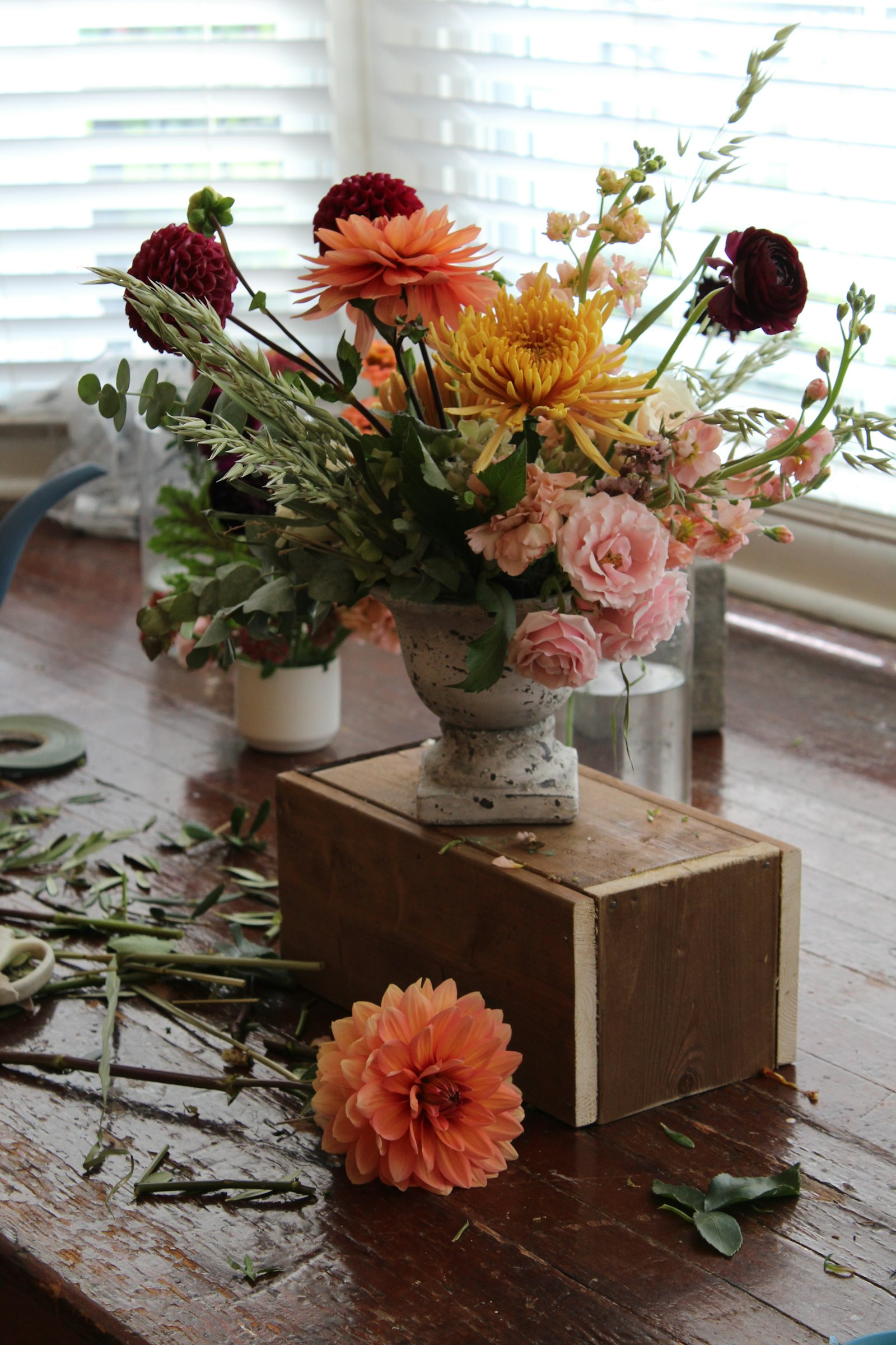 An arrangement in a stone urn by a window