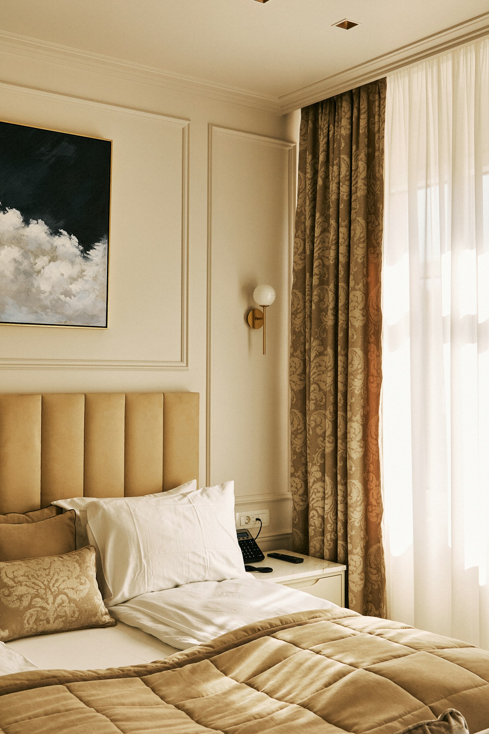 A panelled cream bedroom with a velvet headboard