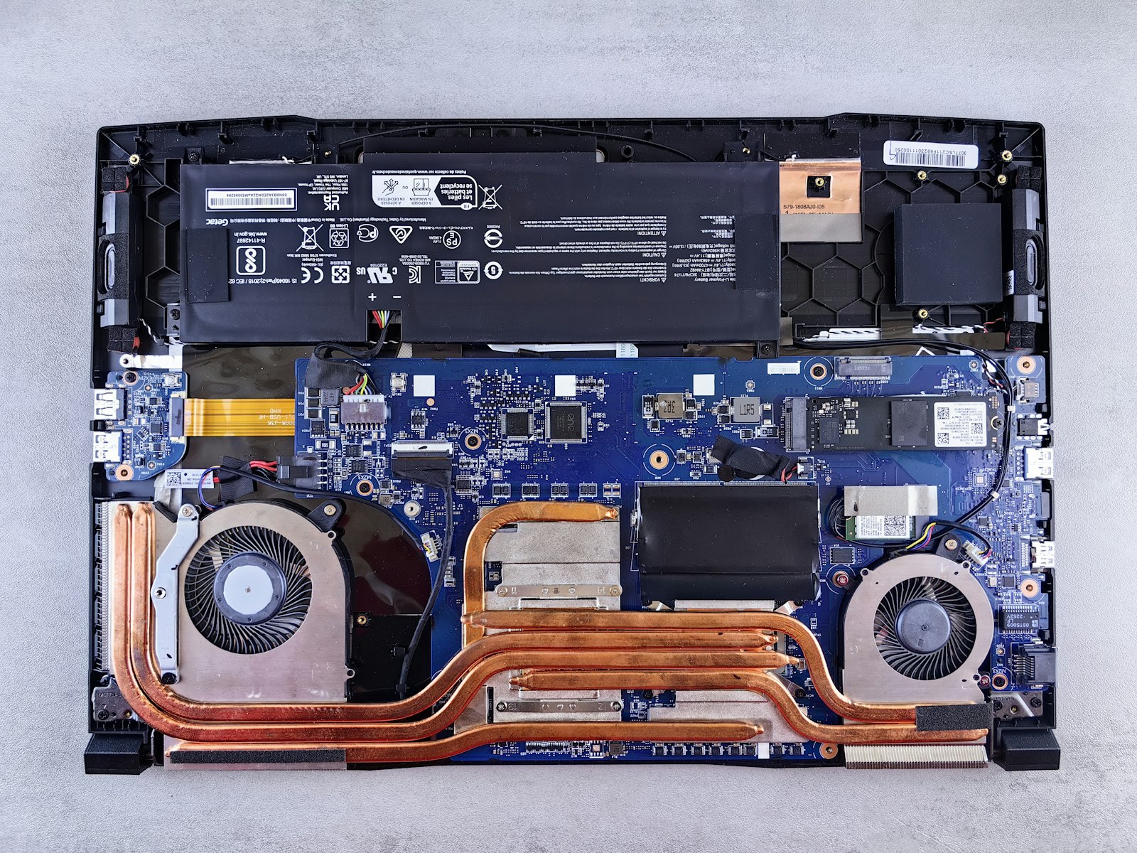 A laptop's insides from above: fans and copper heat pipes