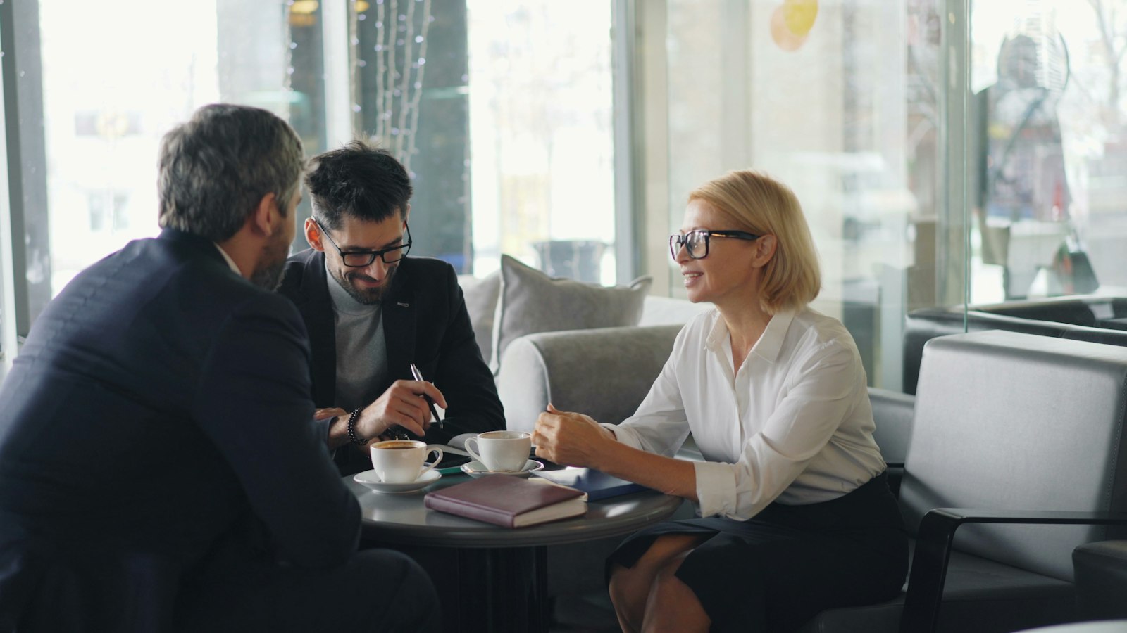 Three people in conversation around a low table