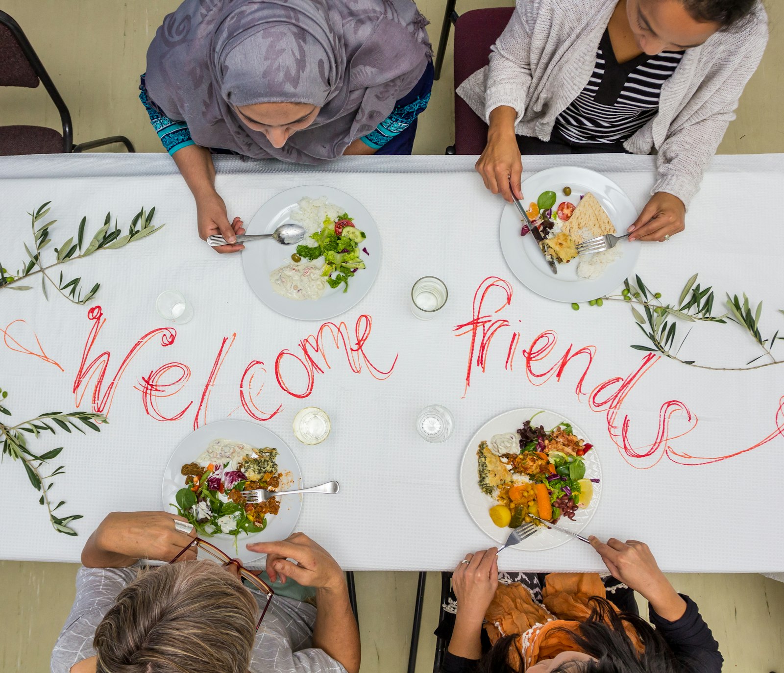 People sharing a meal at a long table, seen from above